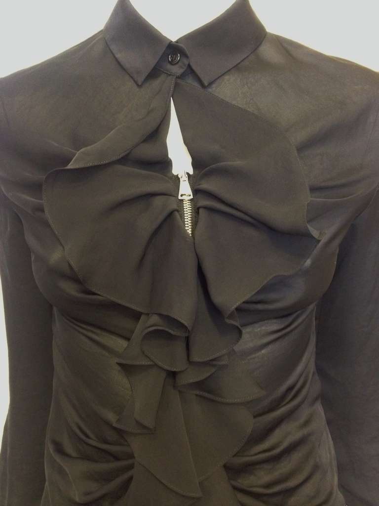 This Givenchy top has both hard edges and soft details - it's feminine and original, dramatic and pretty. A metal zipper is covered by a cascading sheer ruffle that decorates the front of the top, which is loosely gathered to create a ruched effect.