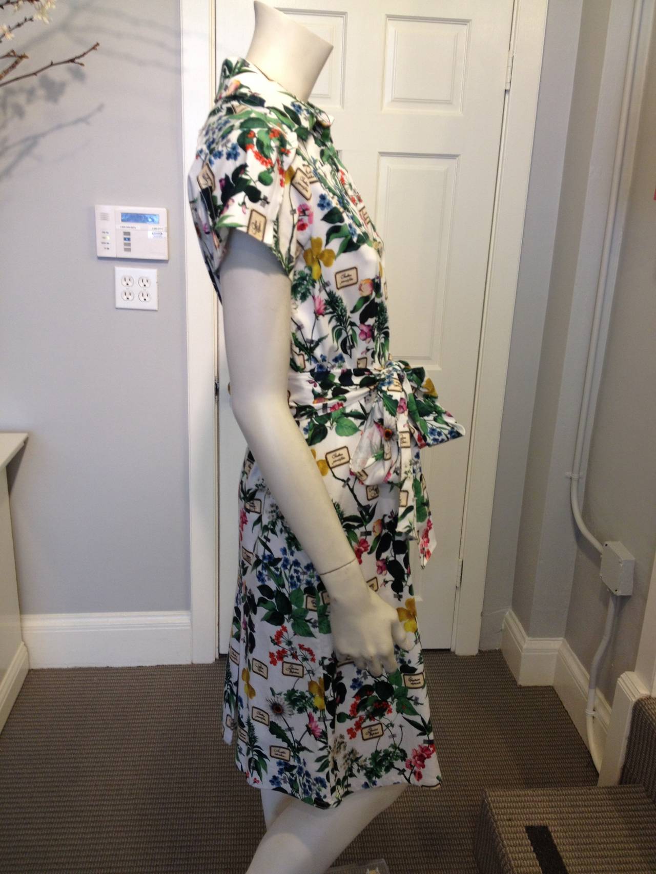 This charming Carolina Herrera dress takes spring florals a step further with its print of an entire collage of trompe l'oeil flowers and foliage that look like they're taped to the fabric, each beside its own label. It  buttons down the front like