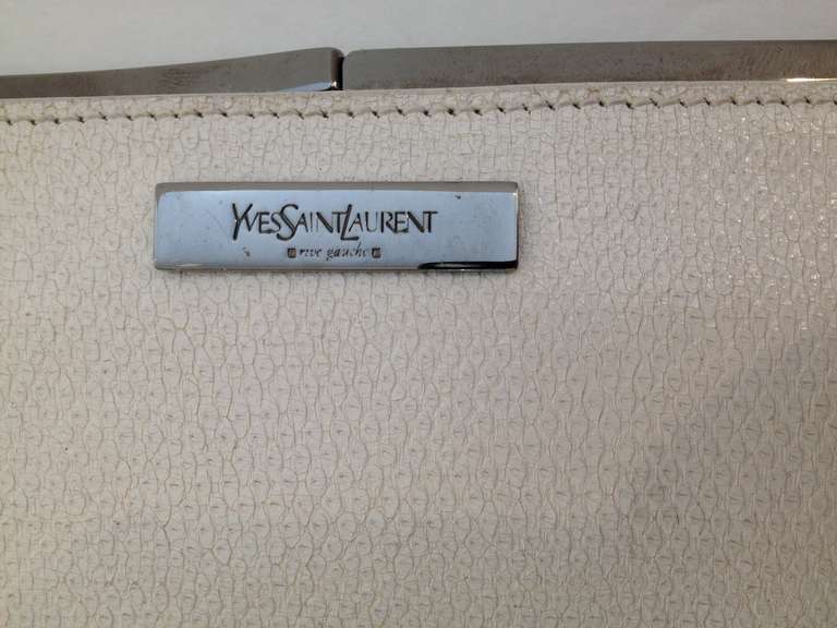 This Yves Saint Laurent clutch is sublime! With a stark minimal design and a super-slim profile, it is both high-impact and subtle, and the white embossed leather and glossy silver fixtures add a modern, almost futuristic elegance. Wear it with a