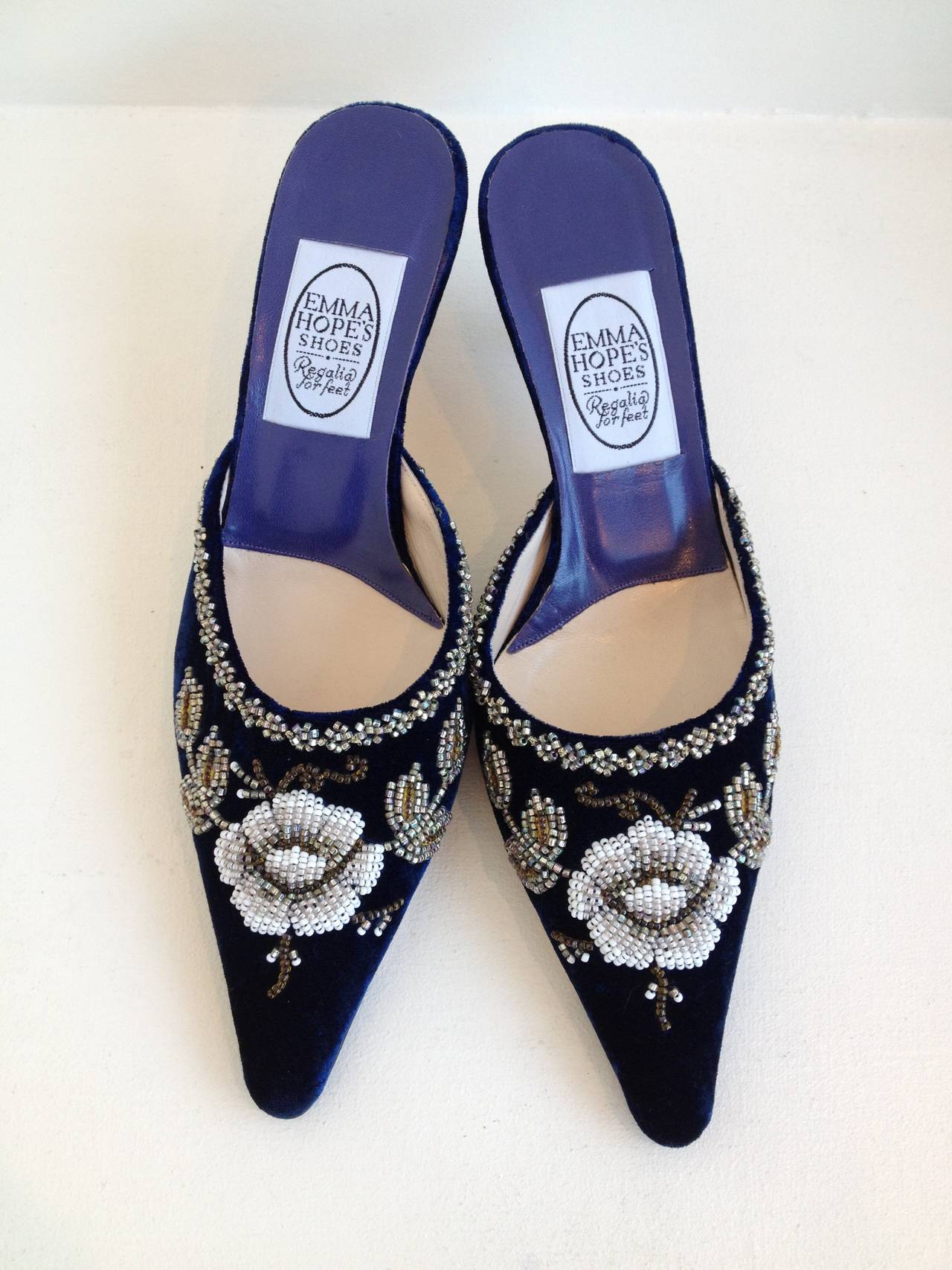 These enchanting heels are a work of art - a beautiful snow white beaded flower decorates each toe, creating a striking contrast with the deep midnight blue velvet. The pointy toe and 2.5 inch heel create a classic shape and silhouette, while the