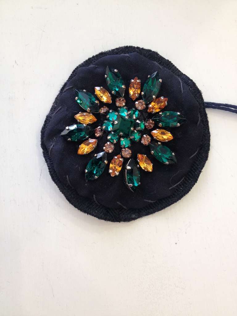 Add a little sparkle to your wardrobe!  This brooch is the perfect accessory to dress up a jacket or blouse.  The multifaceted crystals add elegance and the beautiful kelly green and golden crystals add a pop of color against the black cloth backing.
