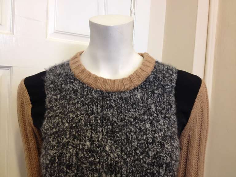 This gorgeous Reed Krakoff sweater offers an entirely new take on colorblocking. Eschewing bright colors and contrasts for a range of textures and feelings, this sweater combines super-soft, nubby heather grey, smooth black silk weave, and oversize