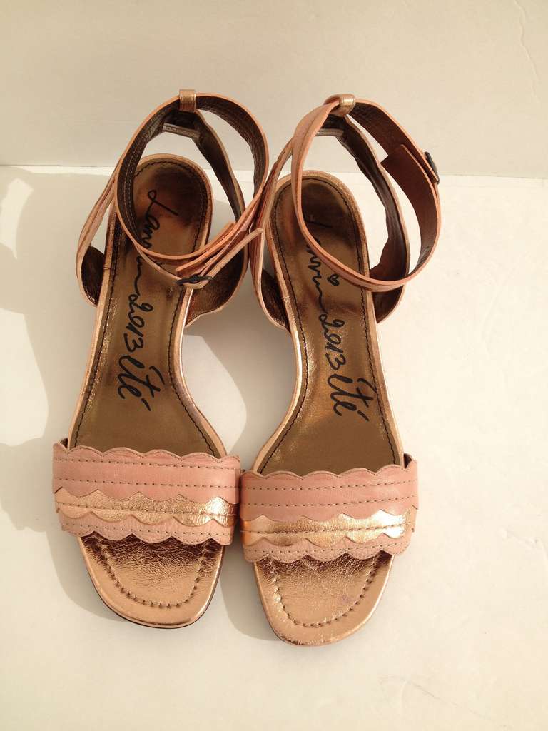 From morning til night, these sandals are all you'll need for summer. Alternating metallic and matte rosy copper straps with adorable scalloped edges, these will  look great paired with a cream colored lace day dress for a walk in the rose garden. 