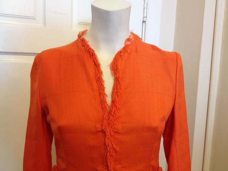 Shake things up in this vibrant Dolce & Gabbana jacket! With fringe lining all along the neckline, sleeve cuffs, hem, and front pockets, it's definitely a statement piece. The bright, saturated tangerine color makes it an especially easy fit for