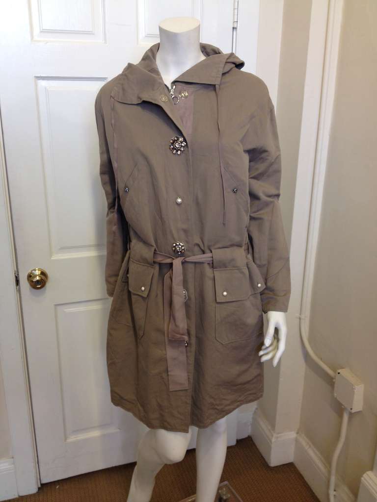 This coat expertly combines a casual every day style with the touch of elegance that every woman craves.  The grosgrain ribbon belt and hood add to the carefree, simplistic style while the gorgeous jeweled buttons and other details add a bit of