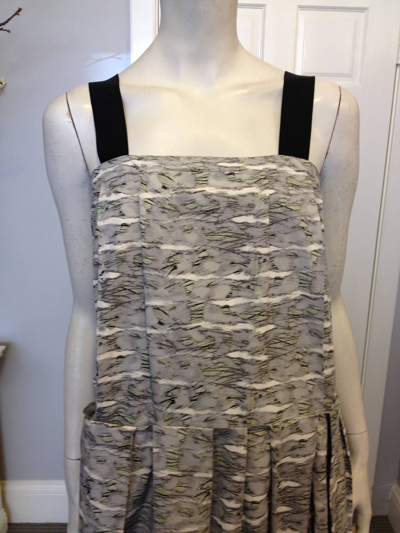 This dress is cut from a beautiful cotton fabric patterned in soft and subtle oyster grey and dusty sage green hues, striated with washed out ultra thin black ink stripes that create an unsual and fully beautiful print. The shoulder straps are made