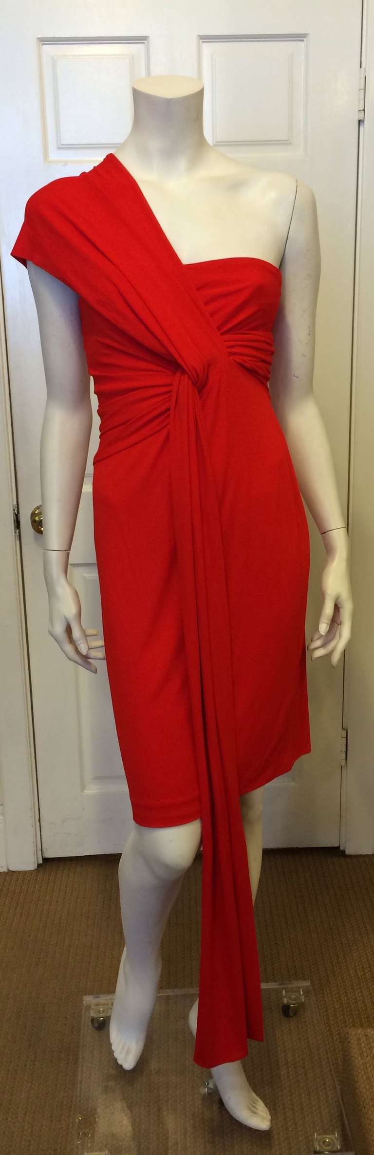 This dramatic red dress is a showstopper! With an attached sash that loops around one shoulder and under the other to create a beautiful draping look, this dress has an archetypical femme fatale feel. Though it looks complex, the twisted front is