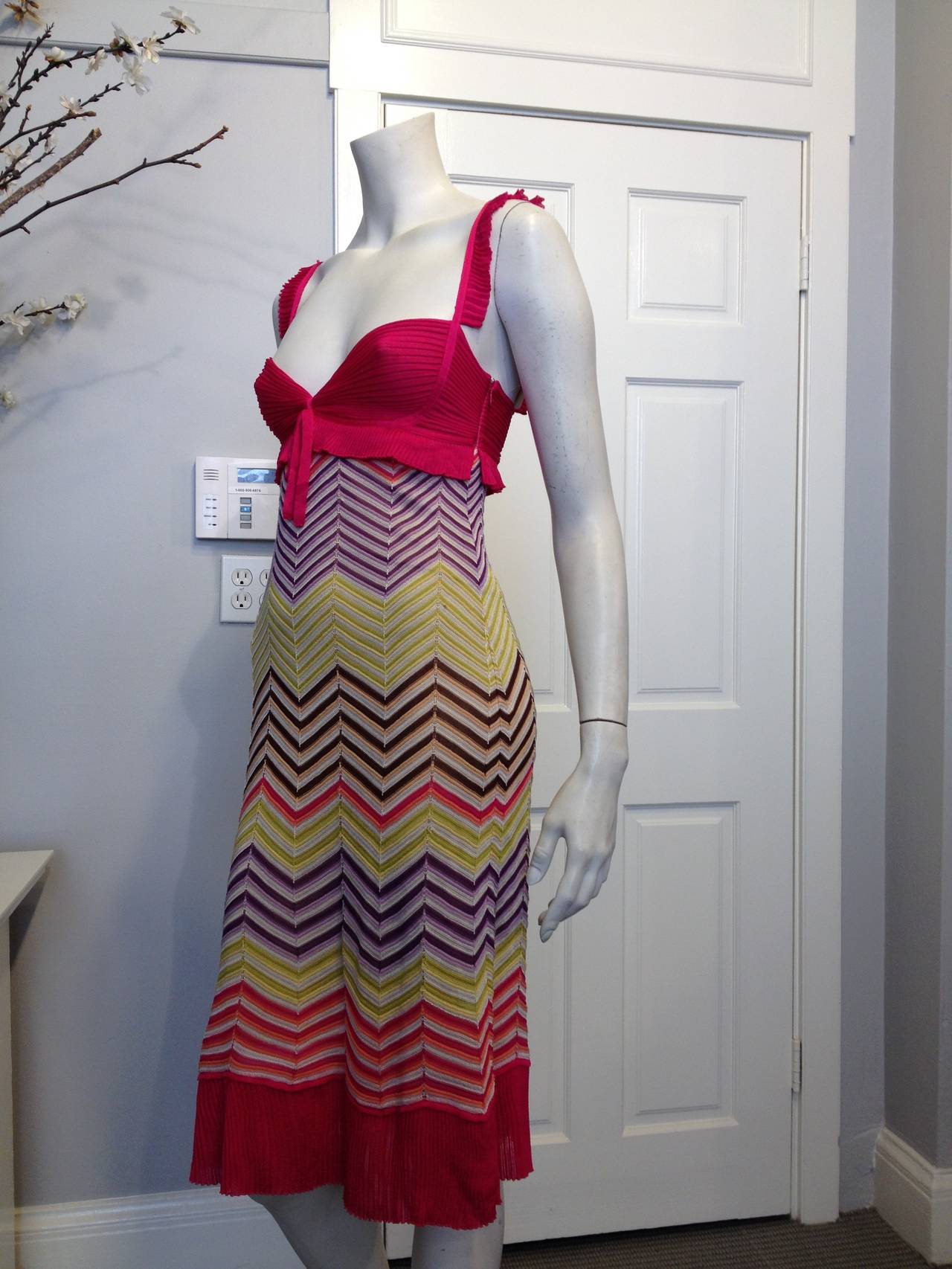 Add a bright splash of color to your summer with this Missoni dress. Vibrant hot pink knit makes the shoulder straps, bust, and hem pop against the chevrons in lavender and eggplant purple, lime and bright yellow. Have a late lunch al fresco or go