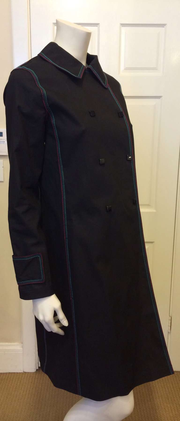 This coat has all the traditional features that one would expect in a trench, plus some fun, colorful details to spice things up!  The triple stitching is all done in green, blue and pink thread, for a youthful feel.  The double breasted buttons are