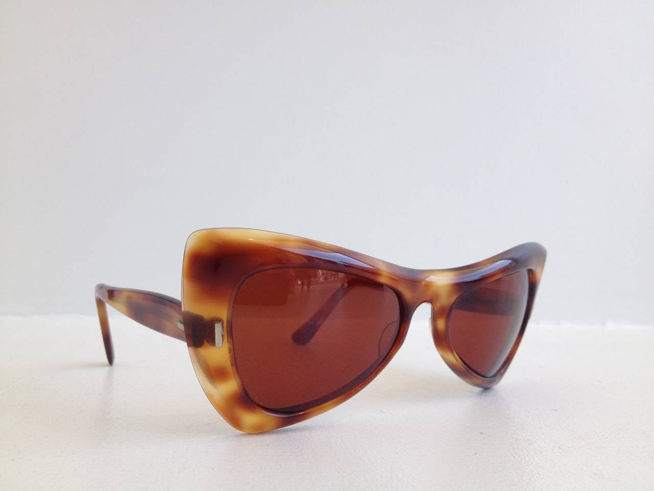Rare and collectible designer Paulette Guinet is known for her surprising and fun designs that rocked the 1950s. This pair is shaped like an exaggerated cateye, extremely angular and elongated, and crafted from a beautiful caramel colored tortoise