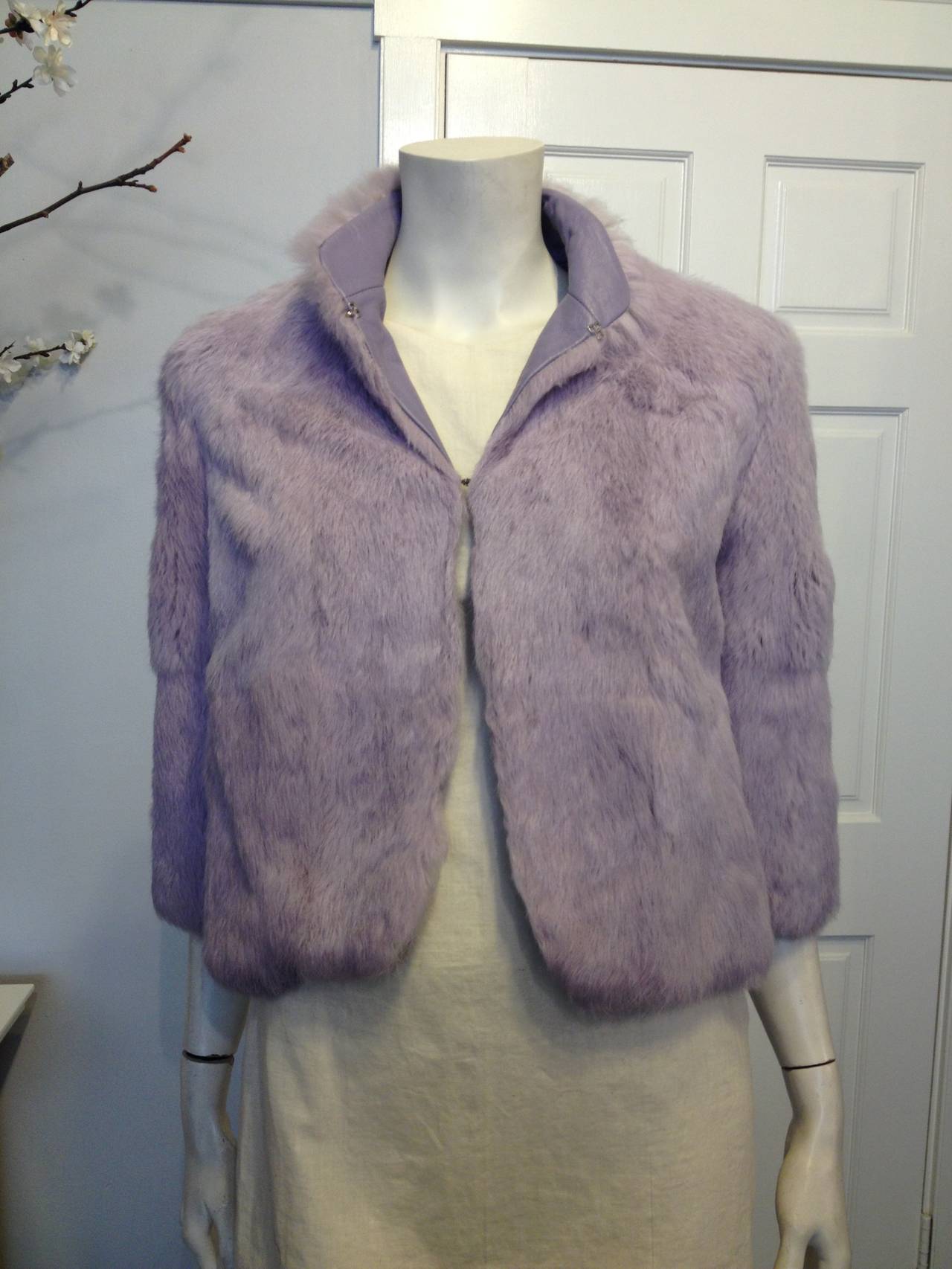 We're absolutely in love with this jacket. Ultra soft velvety fur in enchanting lavender pastel makes it truly special. Two silver clasps - one at the base of the neck and one at the chest - fasten the piece shut, and the interior is lined with a