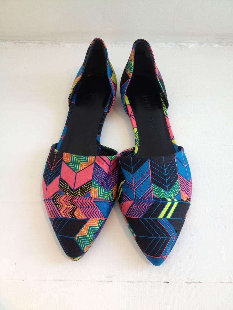 Jenni Kayne's trademark D'Orsay flats go graphic with a neon colored arrow print against black canvas. They feature a pointed toe with panel detail and an open shank.  These flats have a funky, festival vibe and would look great paired with a denim