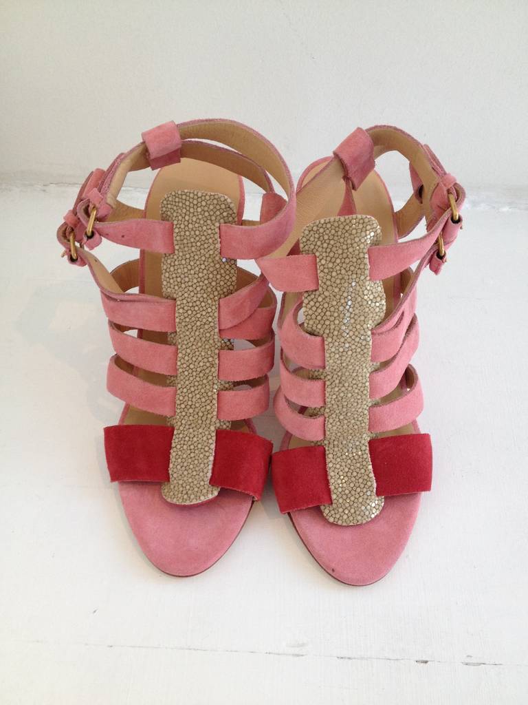 Wow! Balenciaga creates another traffic stopping shoe. These strappy pink suede wedges are stunning with their cream colored stingray embellishment. They feature a magenta colored strap towards the toe for contrast. The wedges have a 4 inch heel and