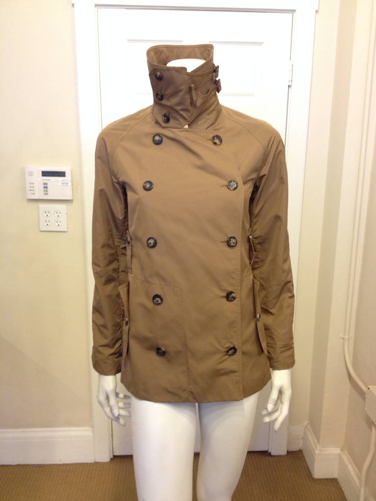 Utility and style come together in this super chic dark beige military inspired rain jacket by Yves Saint Laurent. It's all about details with this jacket, which include two deep side pockets secured with tortoise shell buttons, two vertical