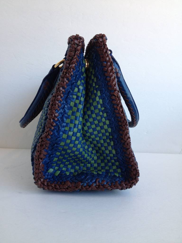 What an amazing bag! Woven strips of leather in saturated deep aquamarine blue, spring green, and chocolate brown create a lattice material that's soft, sturdy, and beautiful. The short handles rise five inches from the top of the bag, while the