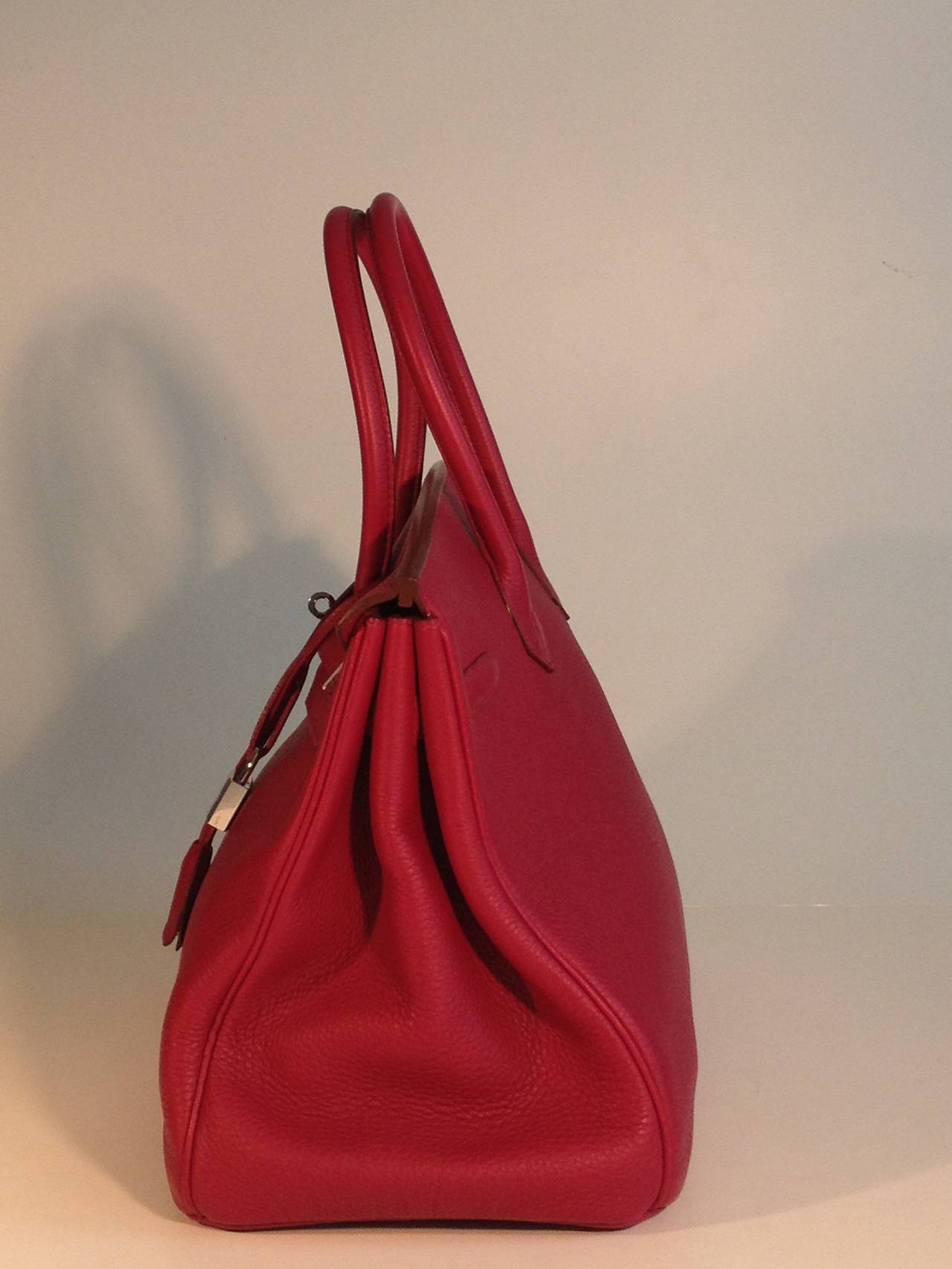 Gorgeous pebbled Clemence leather is absolutely perfect in this fabulous taspberry red color. The Birkin is one of the most prominent symbols of elegance and luxury, and the substantial and spacious 35cm size in a deep and bold color like this is