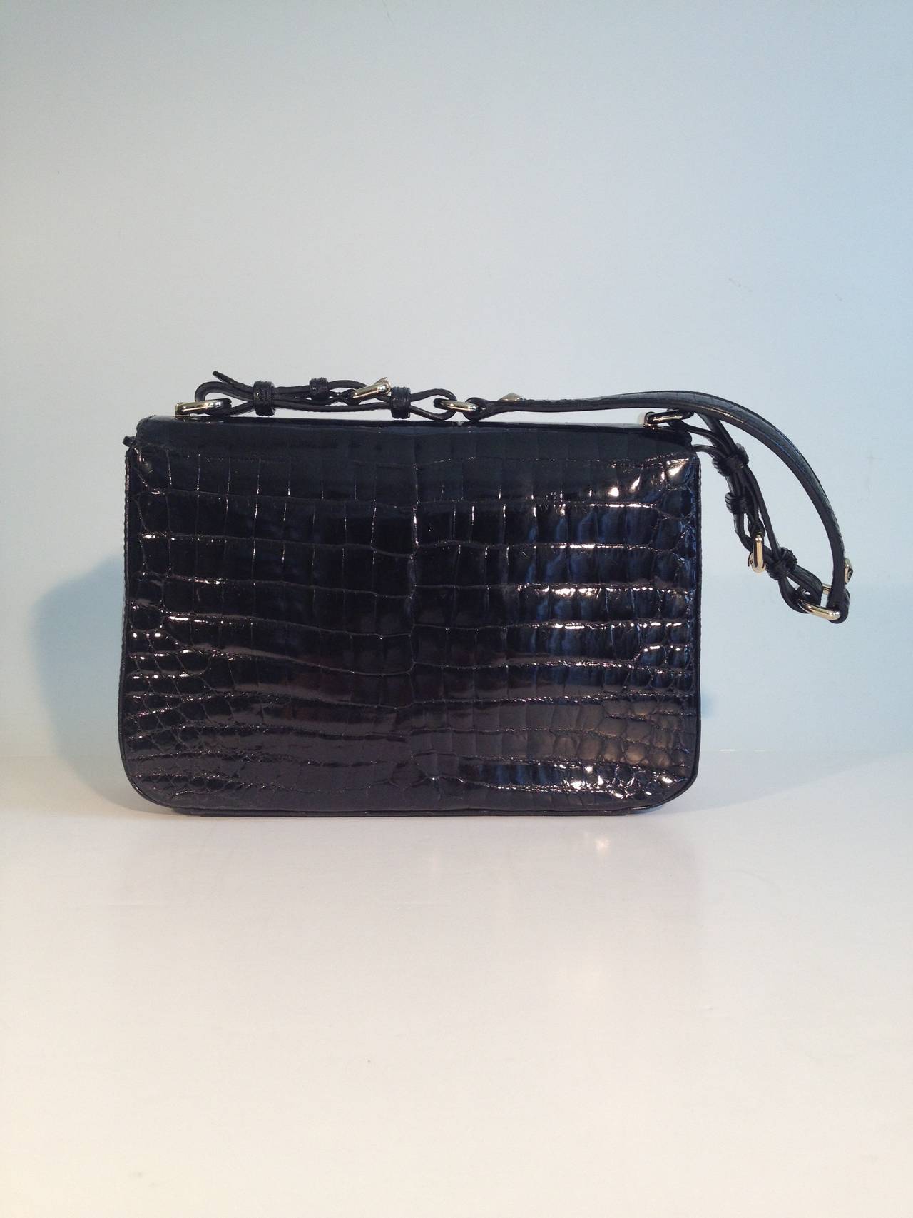 Super high shine black crocodile will never go out of style. By Christian Dior, this piece is the epitome of timeless luxury, while at the same time remaining modern and ultra stylish - the top of the bag features a double flap closure, with