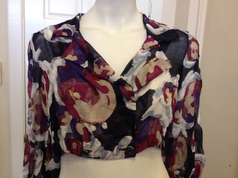 This Chanel jacket is so bold - the super cropped length is perfect for wearing over a fitted dress or with high waist jeans and a bandeau. The material is sheer, and printed with an abstract floral in magenta, purple, cream, and navy blue. The long