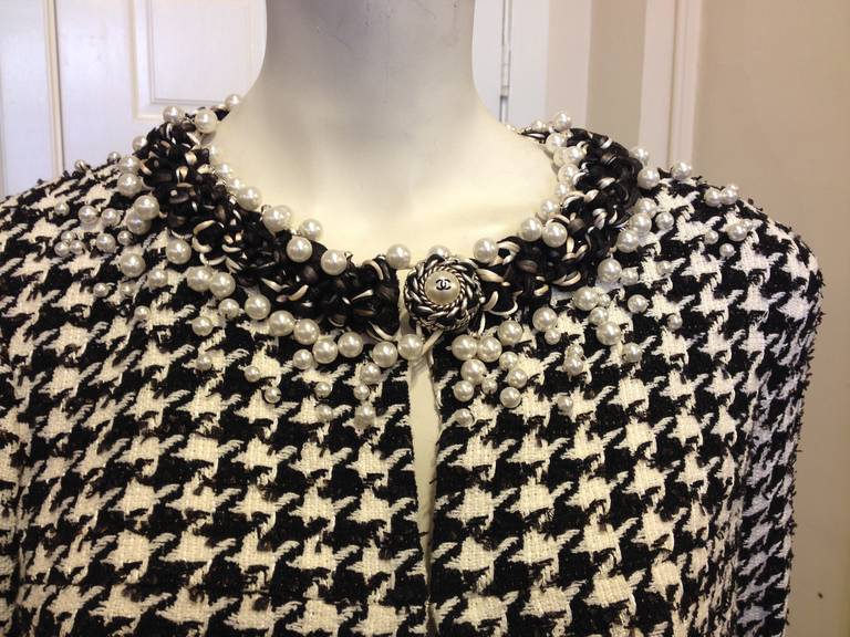 This opulent Chanel jacket has it all!  The classic hounds-tooth pattern is perfection.  And what woman doesn't love pearls?  Adorning the neckline, hem and sleeves are many pearls for an elegant and ultra-feminine look.  Wear with a black pencil