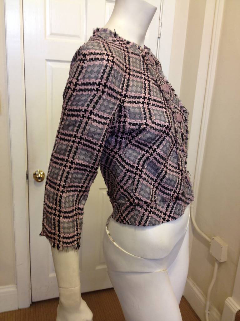 Simultaneously fun and classic, this jacket mixes an easy and simple cut with a fabulously bold weave in a light dusty grey, black, and light pink. This piece is perfect for tossing on with jeans for a day at the office or with a pencil skirt for