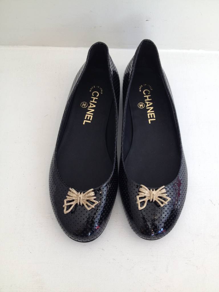 Wear these flats day and night - fabulous, interesting, and fun, they're always perfect. The body of the shoe is made from glossy patent leather with all-over perforation for a futuristic look, while the toe is accented with a little rhinestone gold