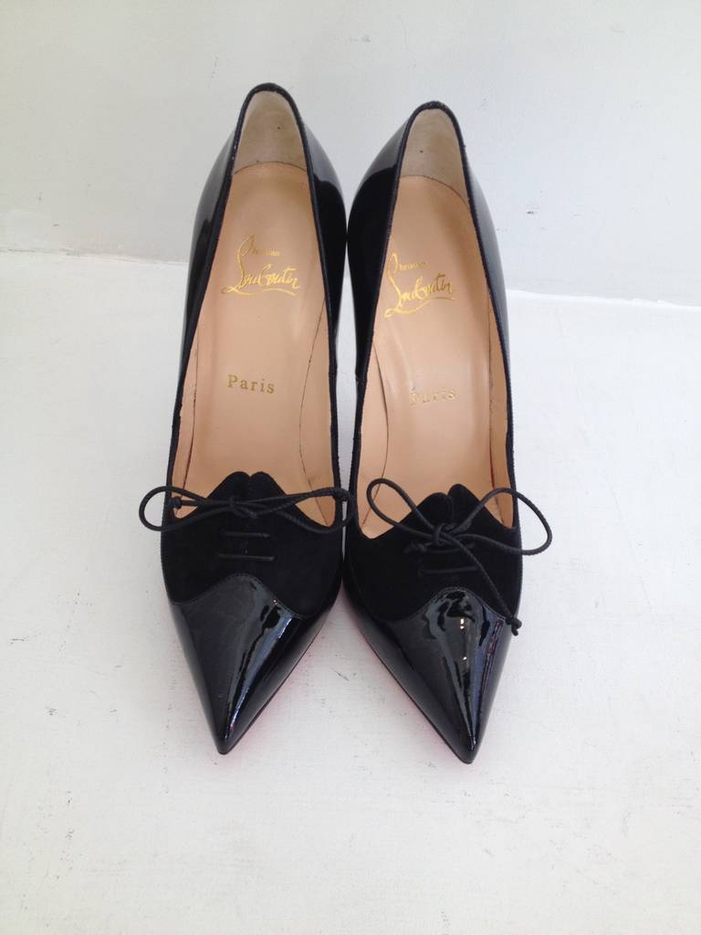 This shoe could an objet d'art with the beautiful and elegant style.  The glossy black patent and exquisite curves are truly stunning.  Black suede contrasts at the toe and features a small shoe lace tied in a bow.  
5 inch heel height