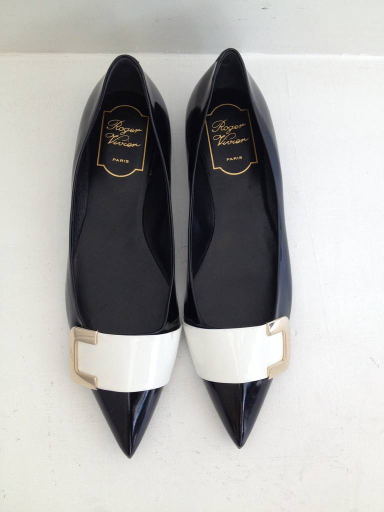 These patent flats are a fabulous update to Roger Vivier's iconic Gommette shoe. The signature oversized buckle and glossy surface are timeless, while gold half-buckle embellishment and the pointy toe add a modern look. The perfect pair to wear with