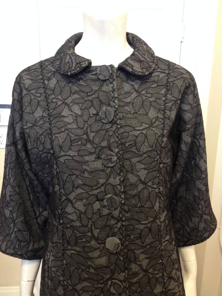 Forget about winter coats being utilitarian and plain - this fabulous Andrew Gn piece is beautiful inside and out. The cozy grey wool is warm and soft, while the beautiful sheer black lace overlay stands out starkly against the grey. This coat is