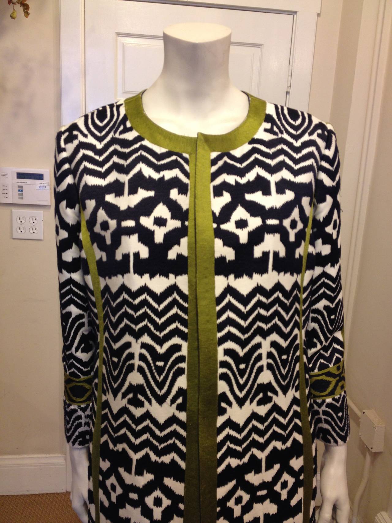 This coat is an amazing piece of art! Soft cream is heavily embroidered with thick navy ikat-style stripes, while bright pea green embroidered stripes accent the high-contrast body. Additionally, each cuff and the hem features rows of white sequins