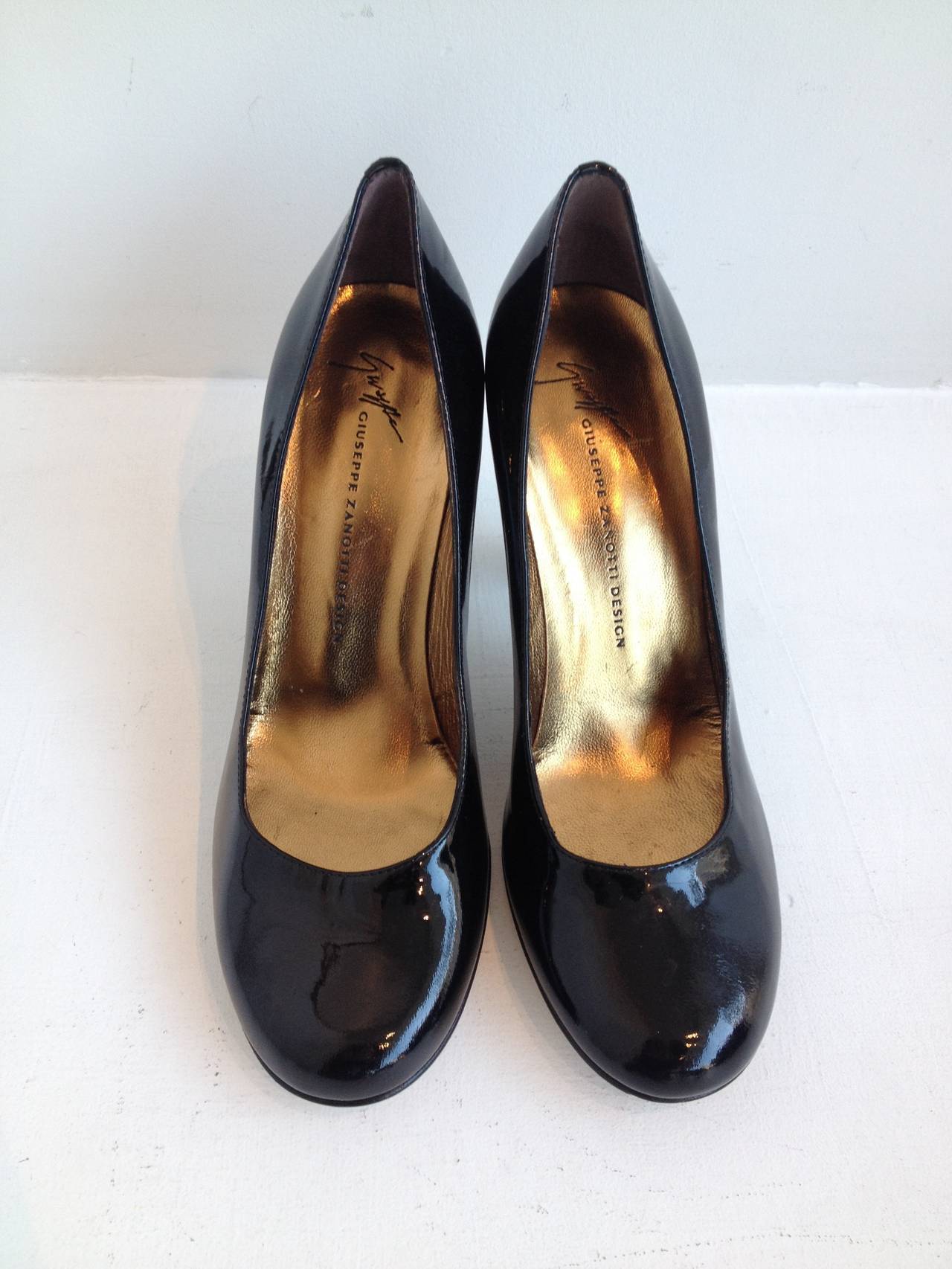 These pumps are a superb addition to any wardrobe. The black patent round-toed body of the shoe has a simplicity that belies the incredible ornate heel - wrought in a glossy bronze-toned metal, it has a fluted shape and textured hammered finish that