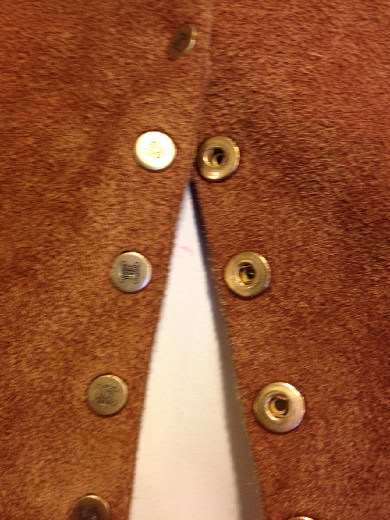 Celine dresses up a rugged western vest with super soft caramel brown suede and glossy gold-toned buttons for a beautiful effect. This vest has a very modern super clean cut - the simple round neckline and straight lines of gold studs adds sleekness