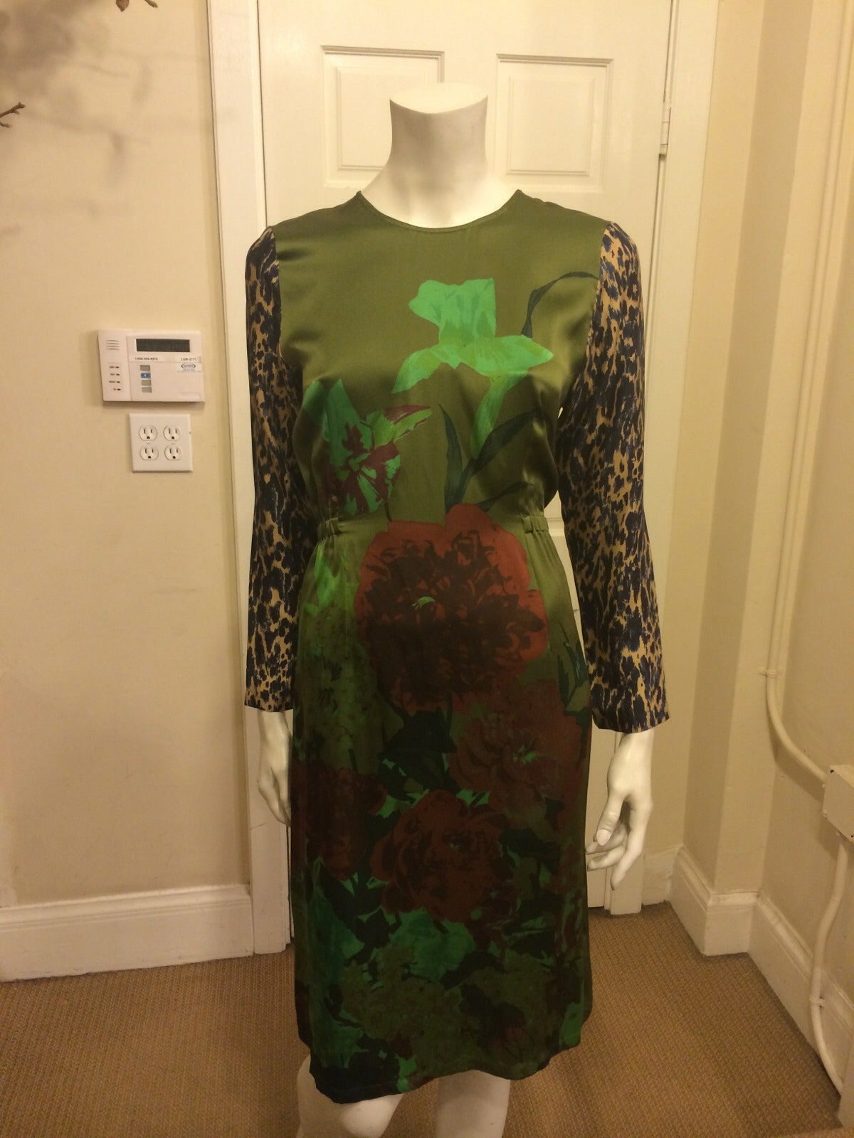 This gorgeous green floral silk dress by Dries Van Noten gets an edgy twist by having contrasting animal print sleeves in beige and navy blue.  The elastic that wraps around the back gives a flattering waistline while maintaining the easy flow of