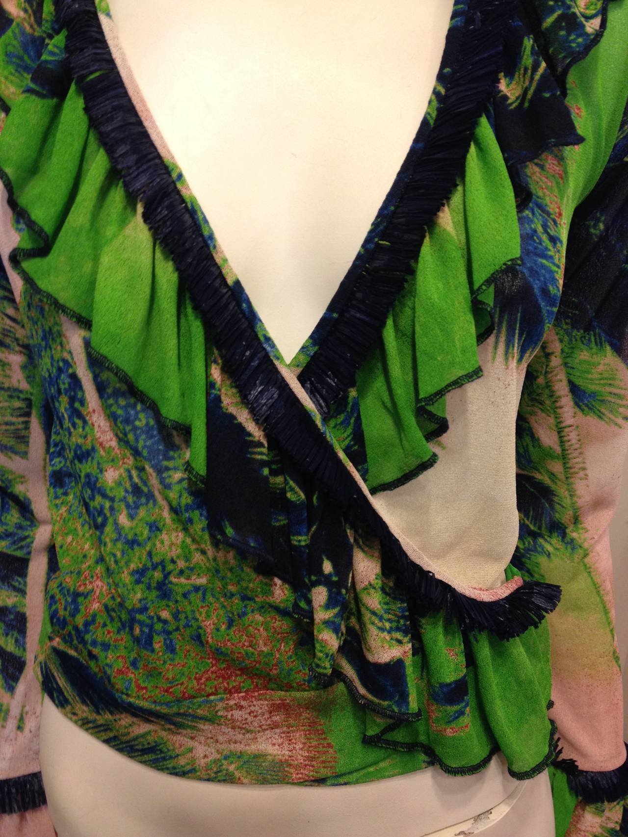 Dream of wandering through tropical jungles and cocktails against a salmon-pink sunset in this fabulously exotic Gaultier top. Palm trees in deep midnight blue, electric green, and soft washed peach tones decorate the fabric while the wrap front