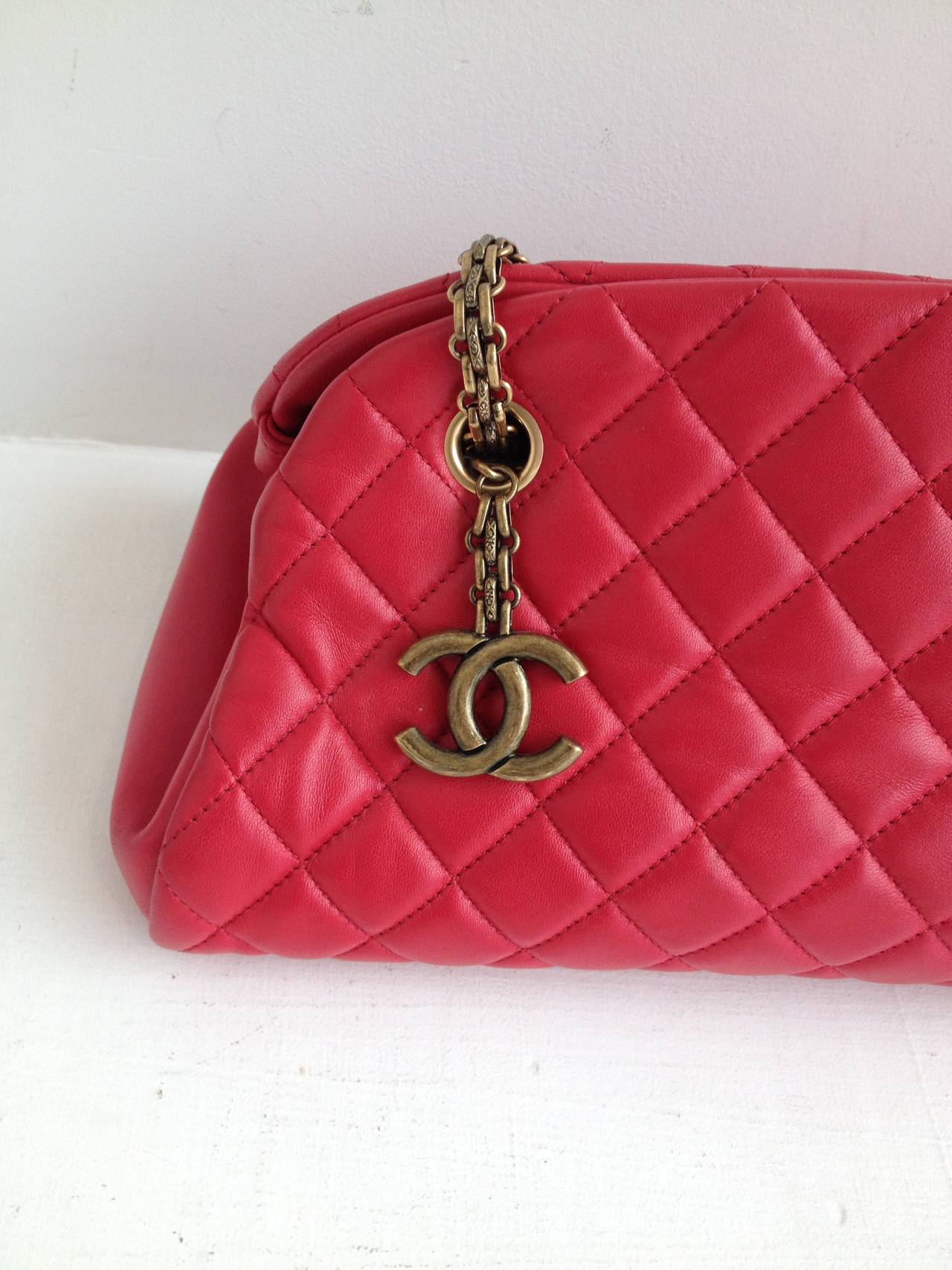 We're in love with this Chanel bag. Red lambskin leather is super soft and supple, and the triangular bar shape of the bag is cool and unusual. The interior features three parallel pockets, one zippered, with one extra leather pocket on one side and