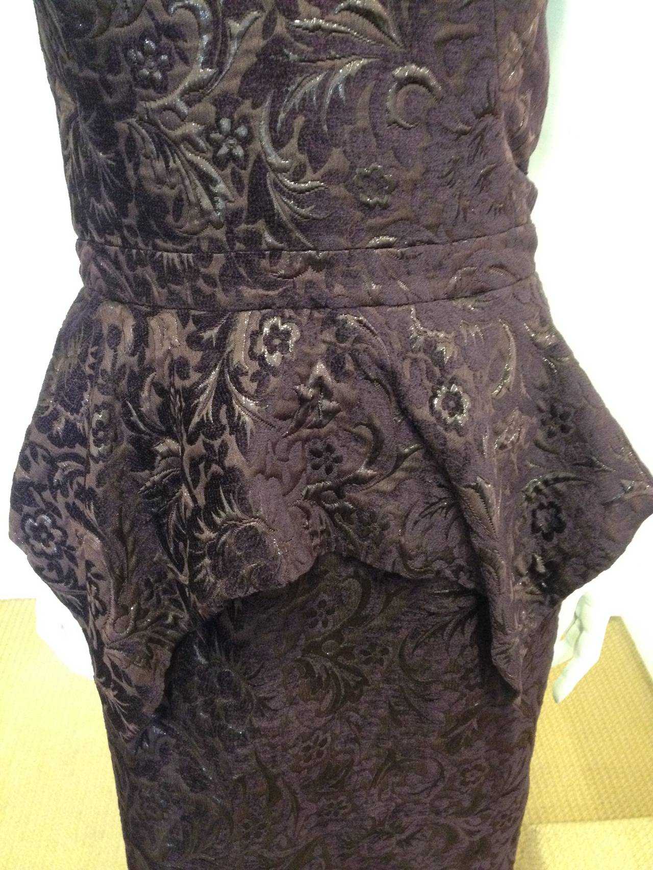 There is nothing more perfect for your next cocktail party. This dress is made from a deep plum velvet brocade that features sparkling lurex threads and a winding floral texture. The strapless sweetheart top is timeless, while the asymmetrical