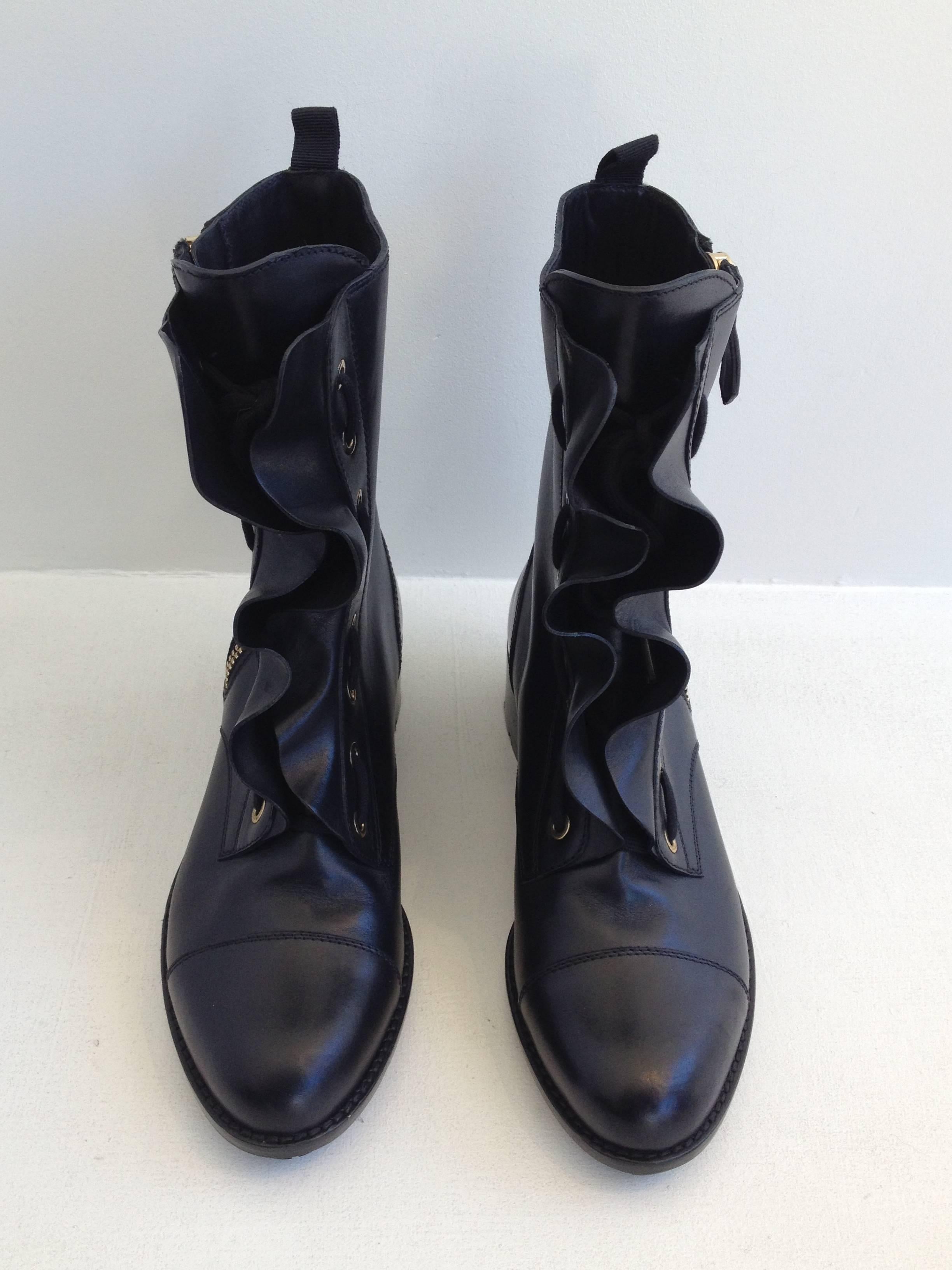 These boots walk the line between sweet and tough. A lovely double ruffle runs from the top of the boot to the toe on either side of the lace-up front, while the outer side of each shoe features a heavy duty gold zipper. The boot rises 9 inches from