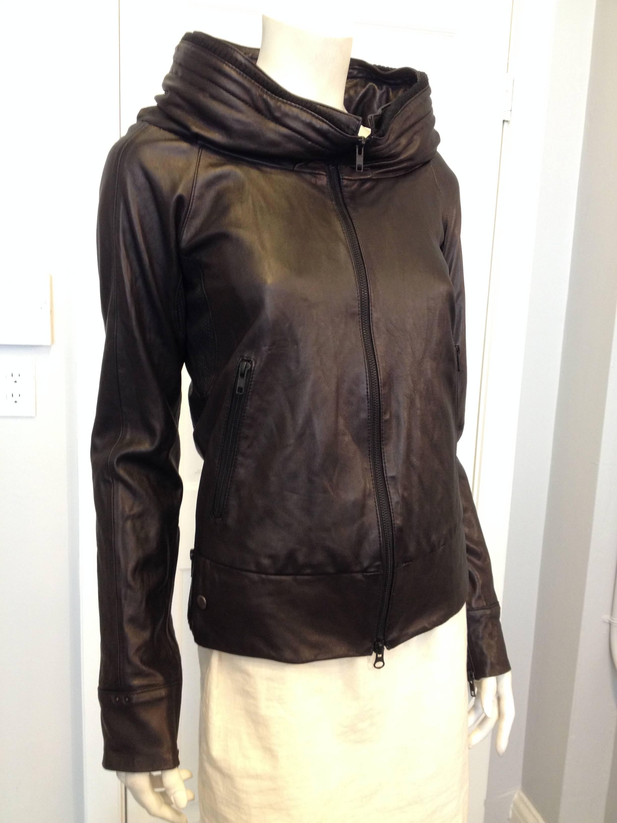 Elegant, dark, and striking, this bomber is strange and at the same time so perfect. Ultra smooth black leather makes the piece feel luxurious, while the cut is slim and lithe. The hemline hits just below the hip, while the high collar sits very