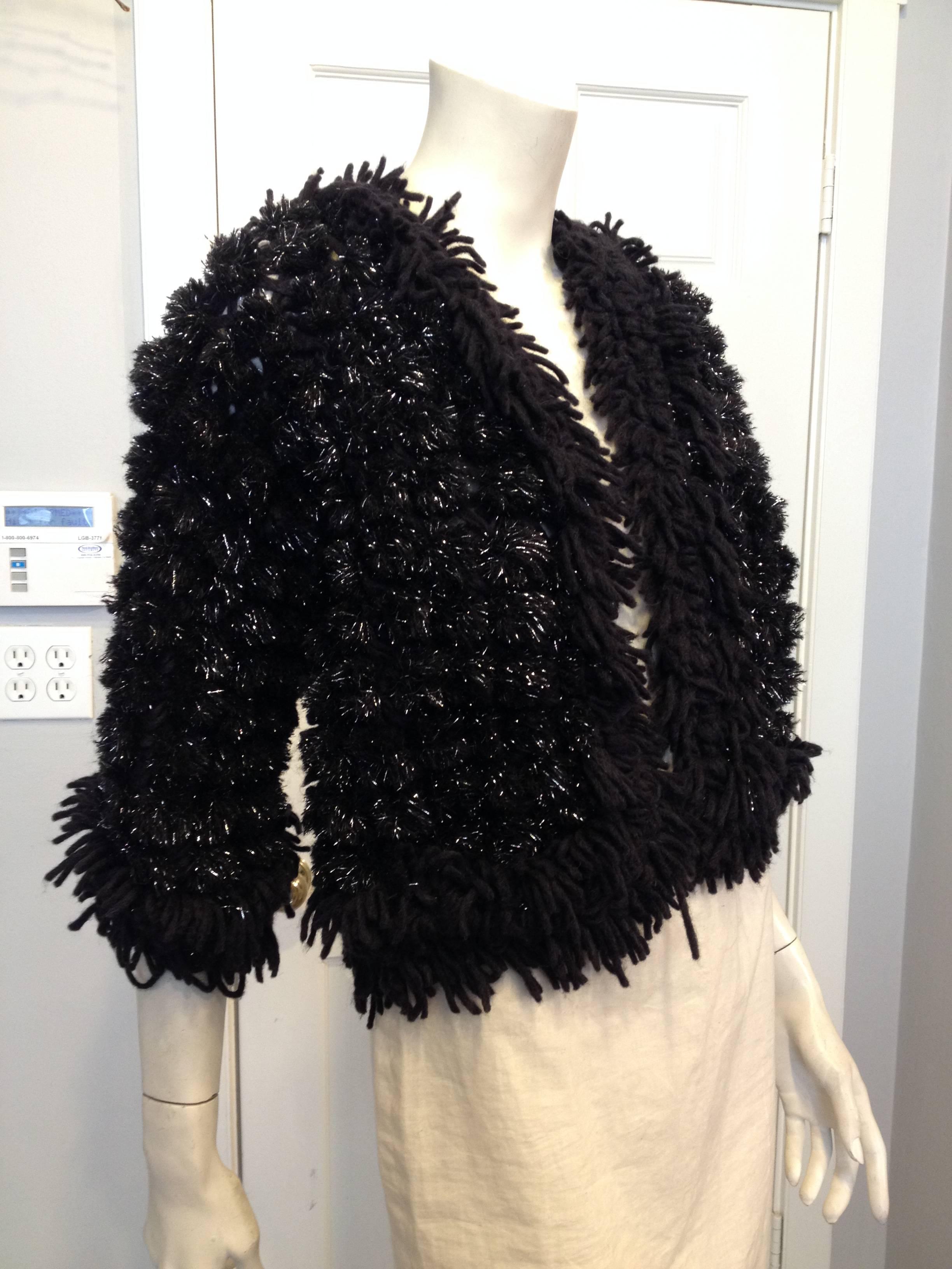 This piece is made entirely from black pom poms laced with sparkling lurex threads, all strung together on a backing web of black yarn. It's cut loose with an open front, fabulous but perfectly casual at the same time - pin the front closed with an