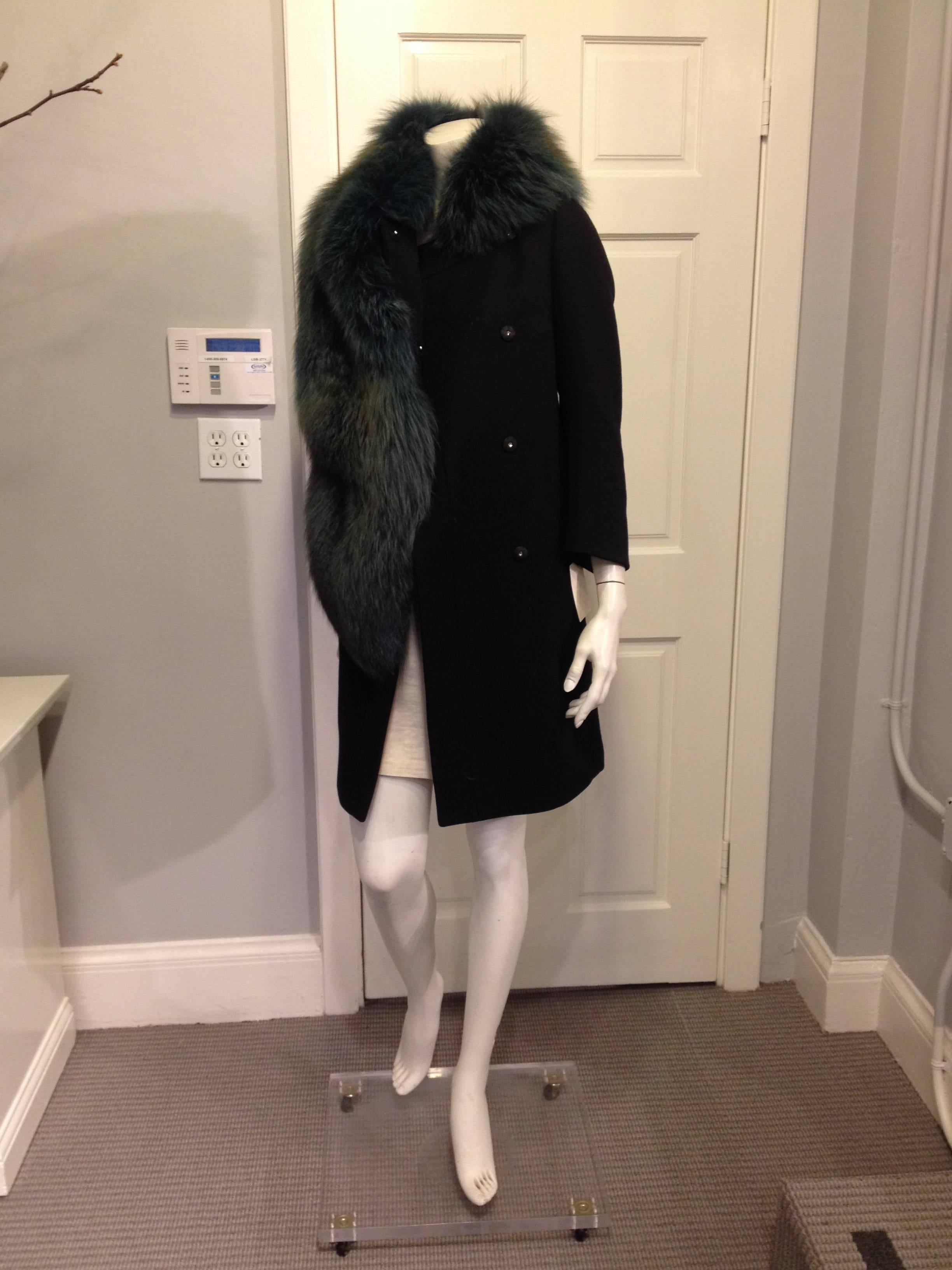 Gorgeous and luxurious dyed fox fur drapes effortlessly around the neck and over one shoulder, a cascade of teal undercoat crowned with aqua topcoat hairs. The shape of the coat is sleek and streamlined, cut slim to contrast the fur. This piece is