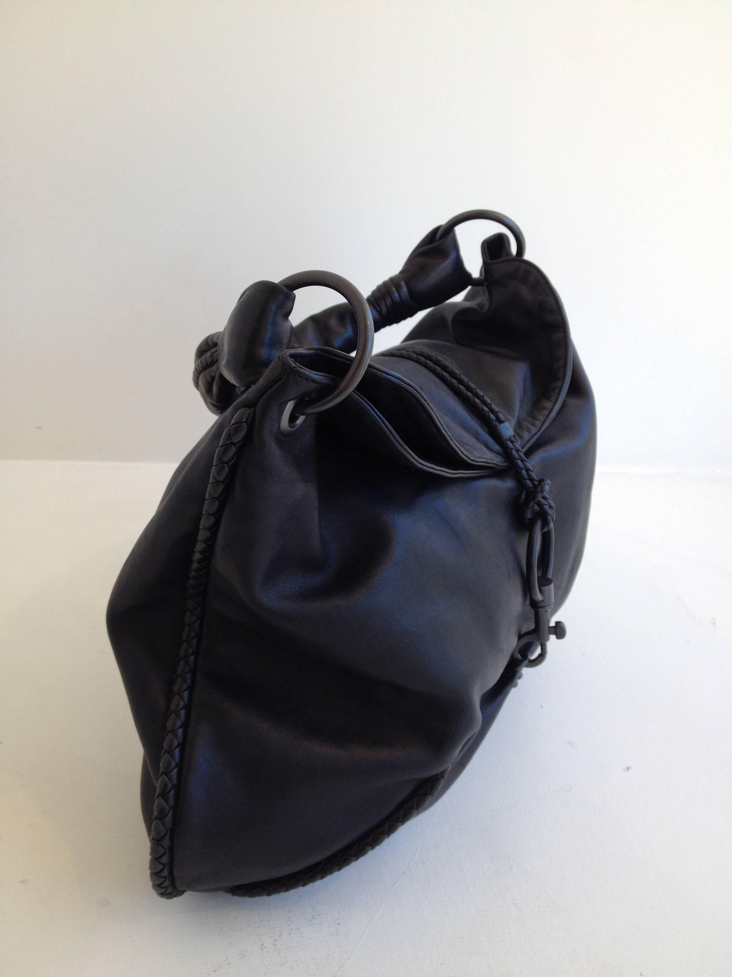 Made from ultra soft black leather and trimmed with little hints of iconic intrecciato trim, this bag is cool and contemporary while staying true to the Bottega legacy. Slouchy but polished, it features two slim woven cords that attach to the spring