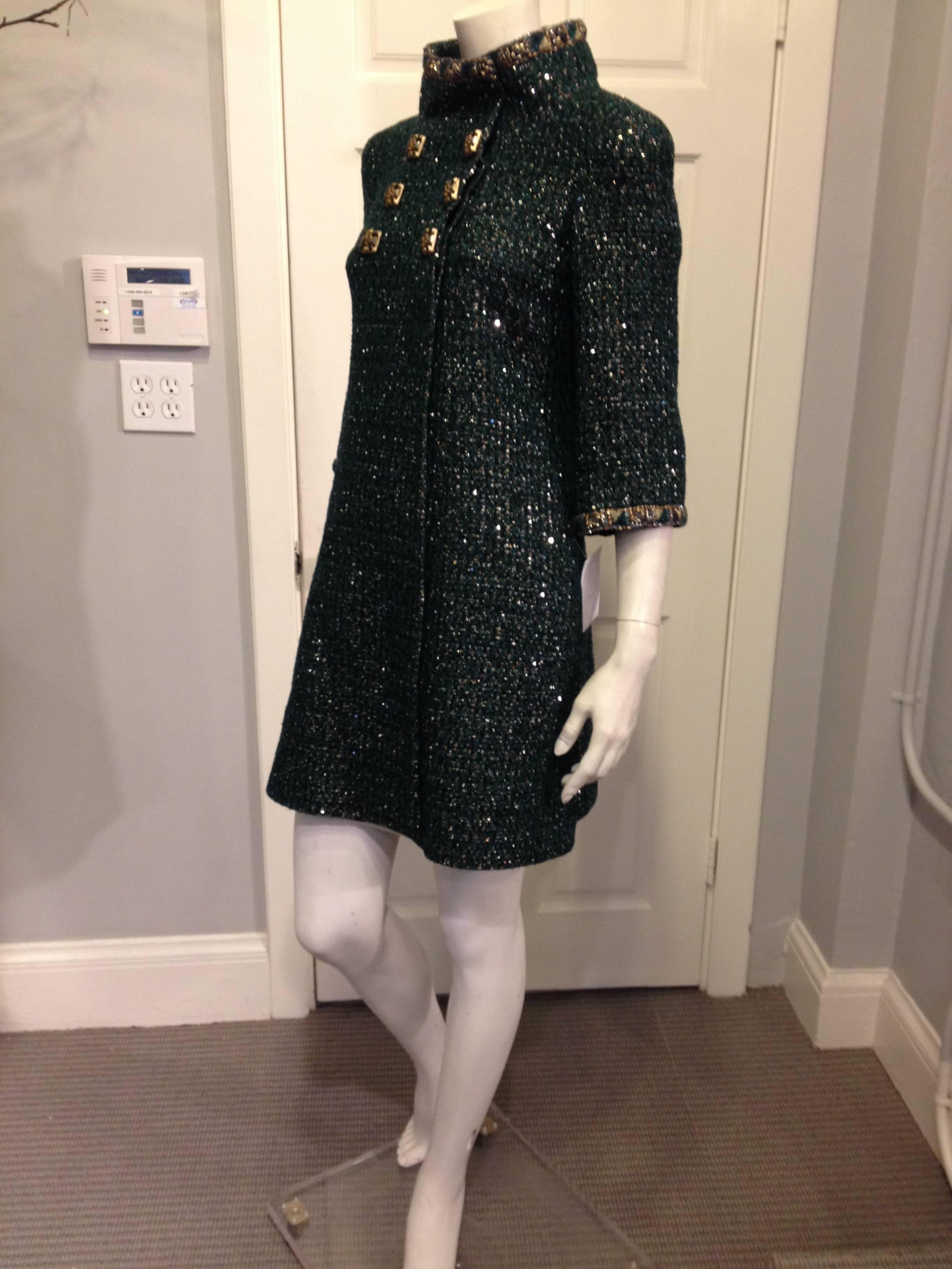 Sparkling dark serpentine green makes this Chanel coat a beautiful and unexpected choice, perfect for glamorous evenings and holiday events. The green tweed is variegated, with flecks of black and gold metallic thread, complementing the gold