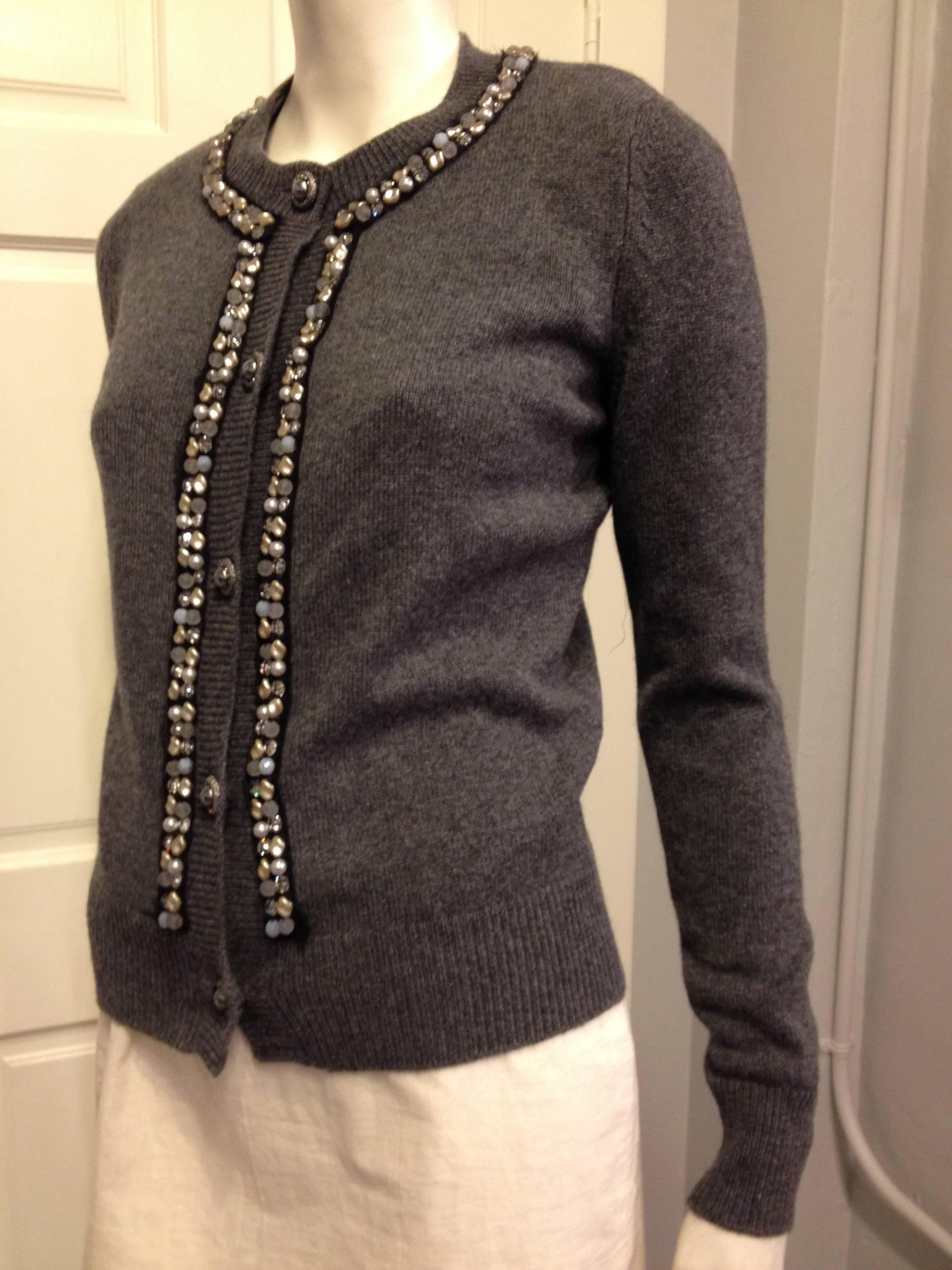Plush, comfortable, and chic in the most Chanel way - this cashmere cardigan in an elegant soft charcoal grey is the most perfect thing. The cut is classic with a round neckline and ribbed trim, while the front is decorated with an assortment of