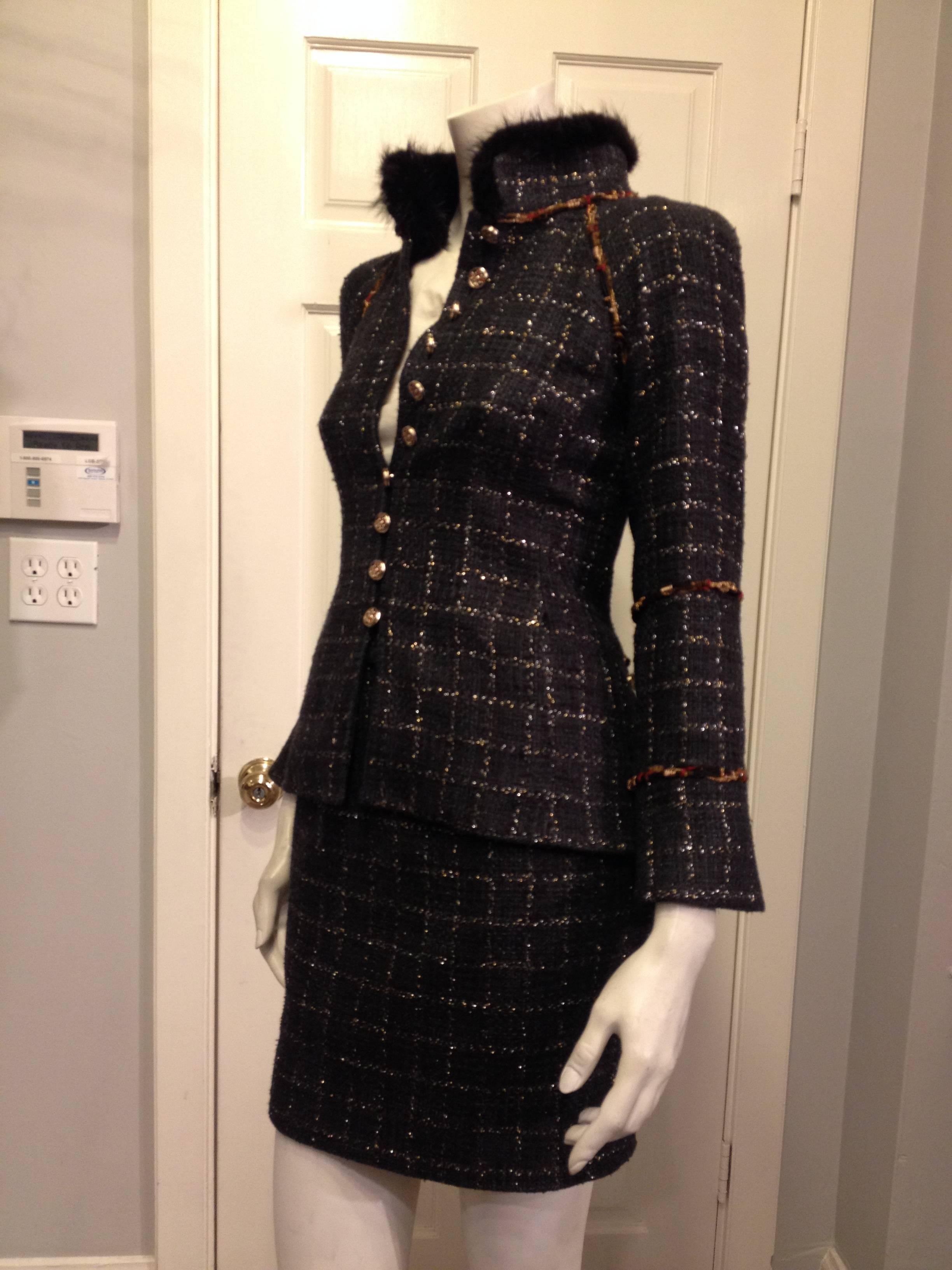 How dramatic and unexpected - this Chanel suit is everything you could want. Gorgeous dark ocean blue tweed is flecked with delicate shiny silver windowpane pattern, while the jacket is decorated with a lovely cord trim in shades of black, copper,