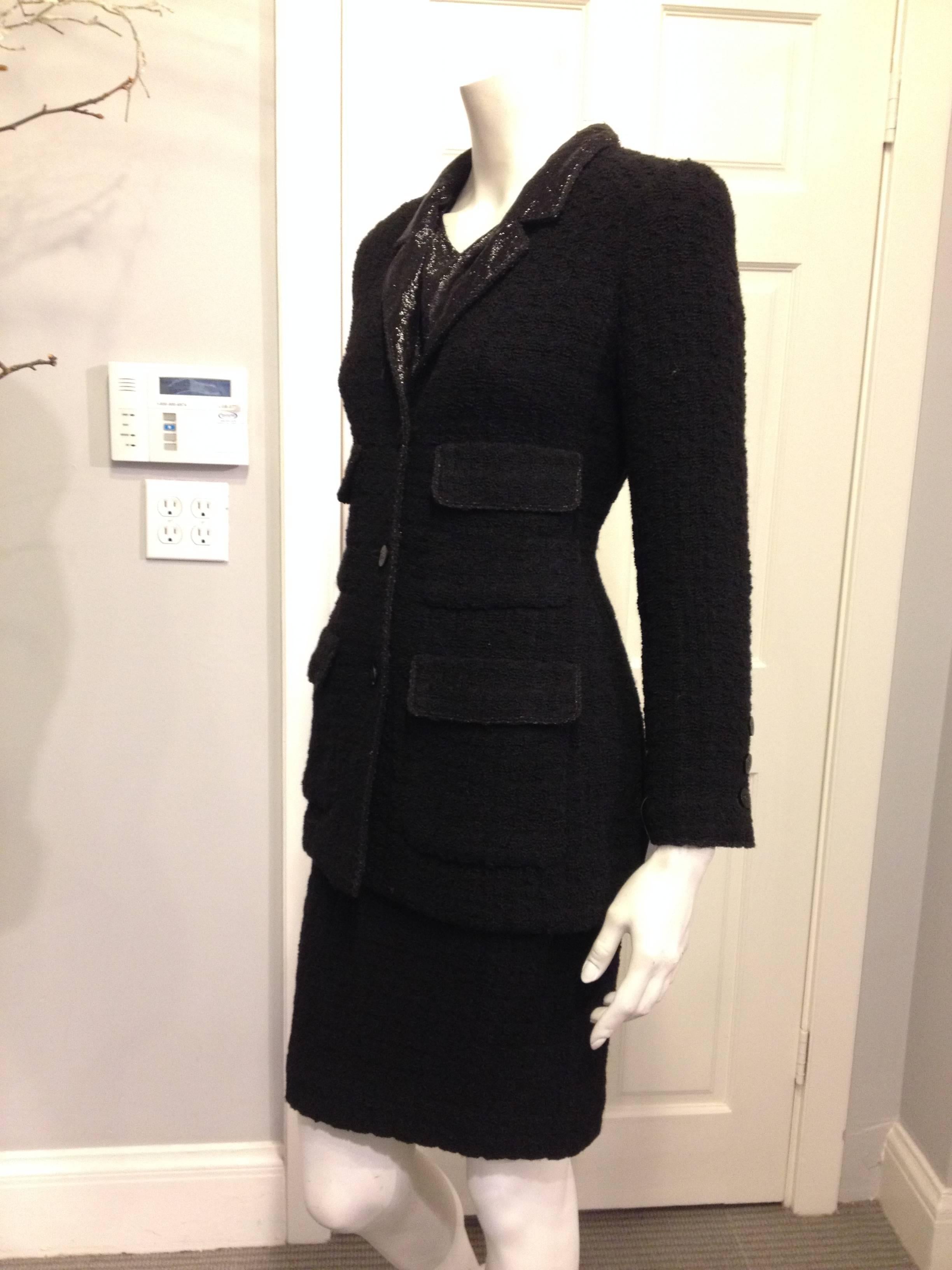 Glamorous but classic at the same time, this three-piece Chanel suit is the ultimate dress-up ensemble. The cut of the jacket is very typically Chanel, with a low hemline, three-button closure, and four pockets on the front of the piece. The skirt