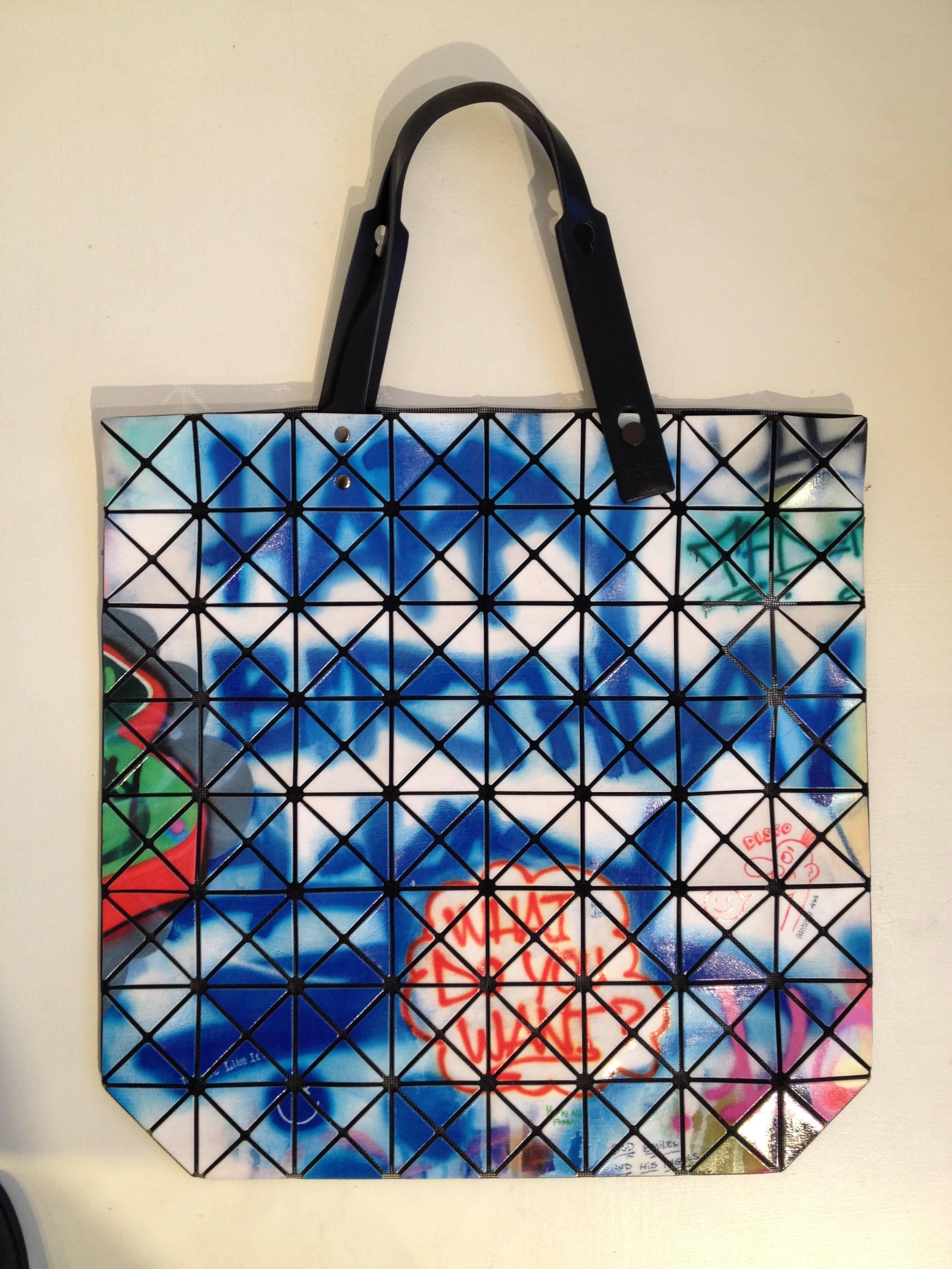 The iconic Bao Bao looks amazing in this vividly colorful graffiti print. Ultra durable and super lightweight, this bag is as functional as a tote as it is a statement bag. The tiles are mounted on a mesh backing that makes it collapsible and lets