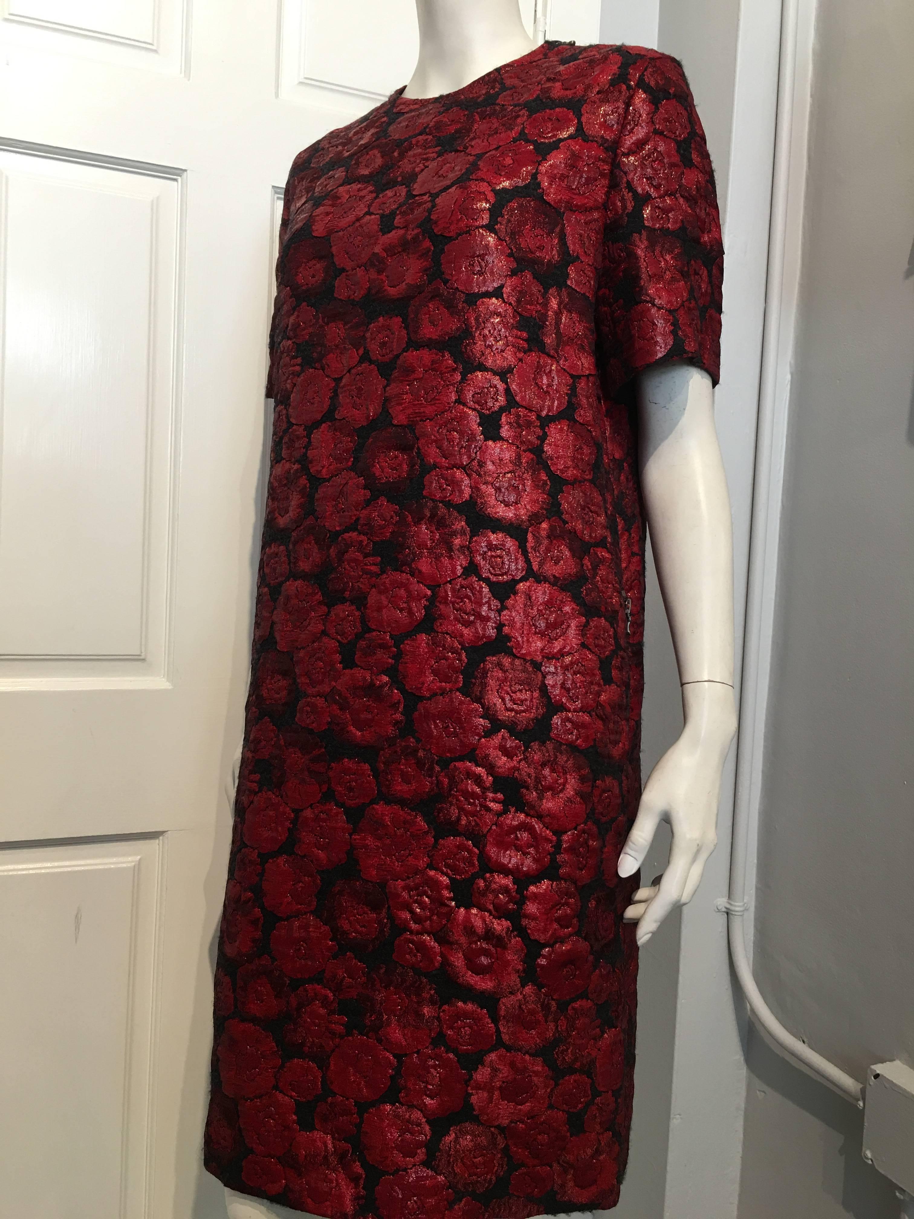 Lanvin dress in black wool with shiny red floral design. It has a bronze colored zipper on the left shoulder and zipper on each of the side pockets. The sleeves are 10