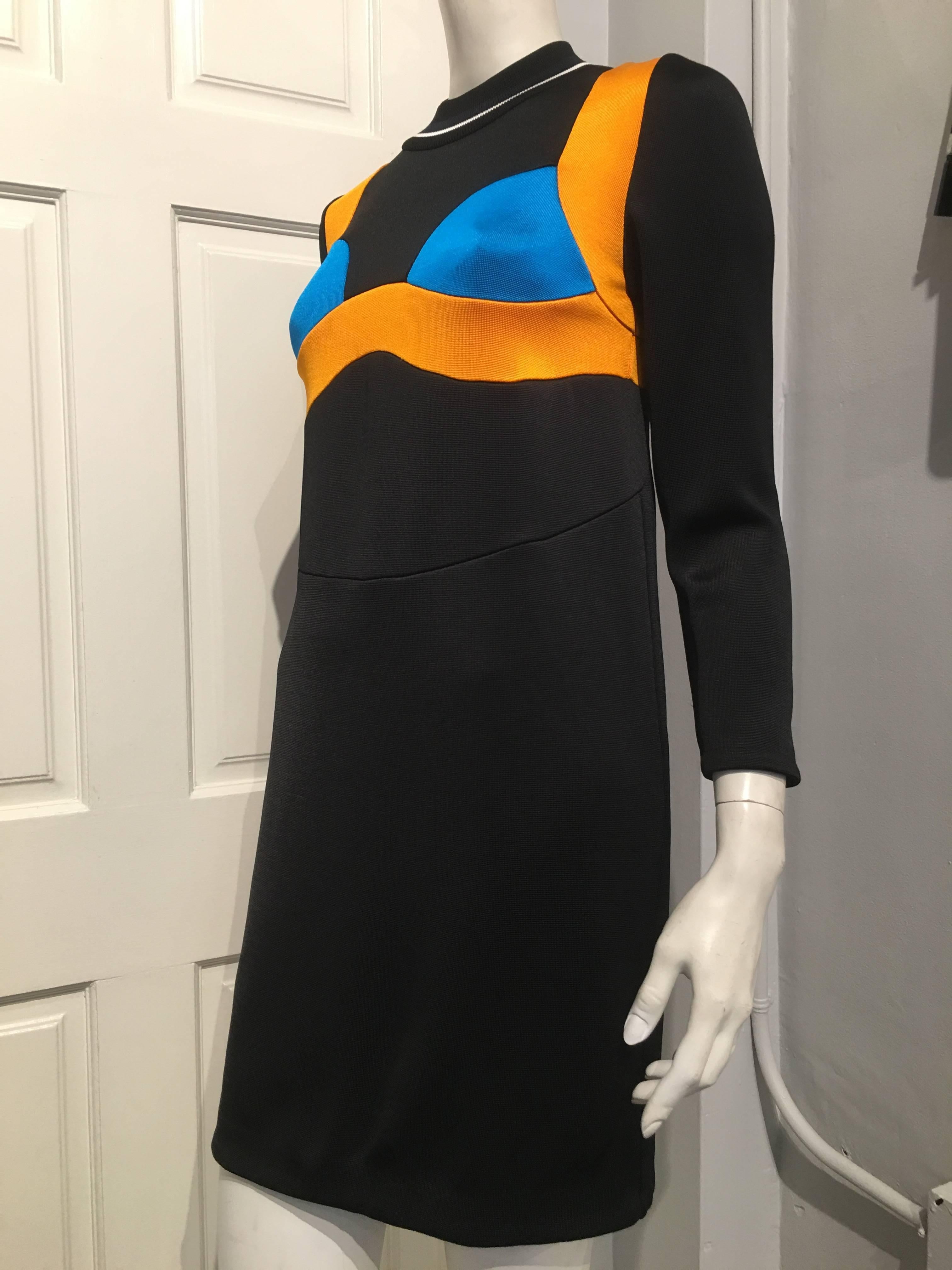 This Prada dress is part of the 2014 spring/summer ready-to-wear collection. It features a mock bra in turquoise and goldenrod, and a white and dark navy band on the ribbed collar. The top and skirt are attached by a seam. The sleeves are 22 inches