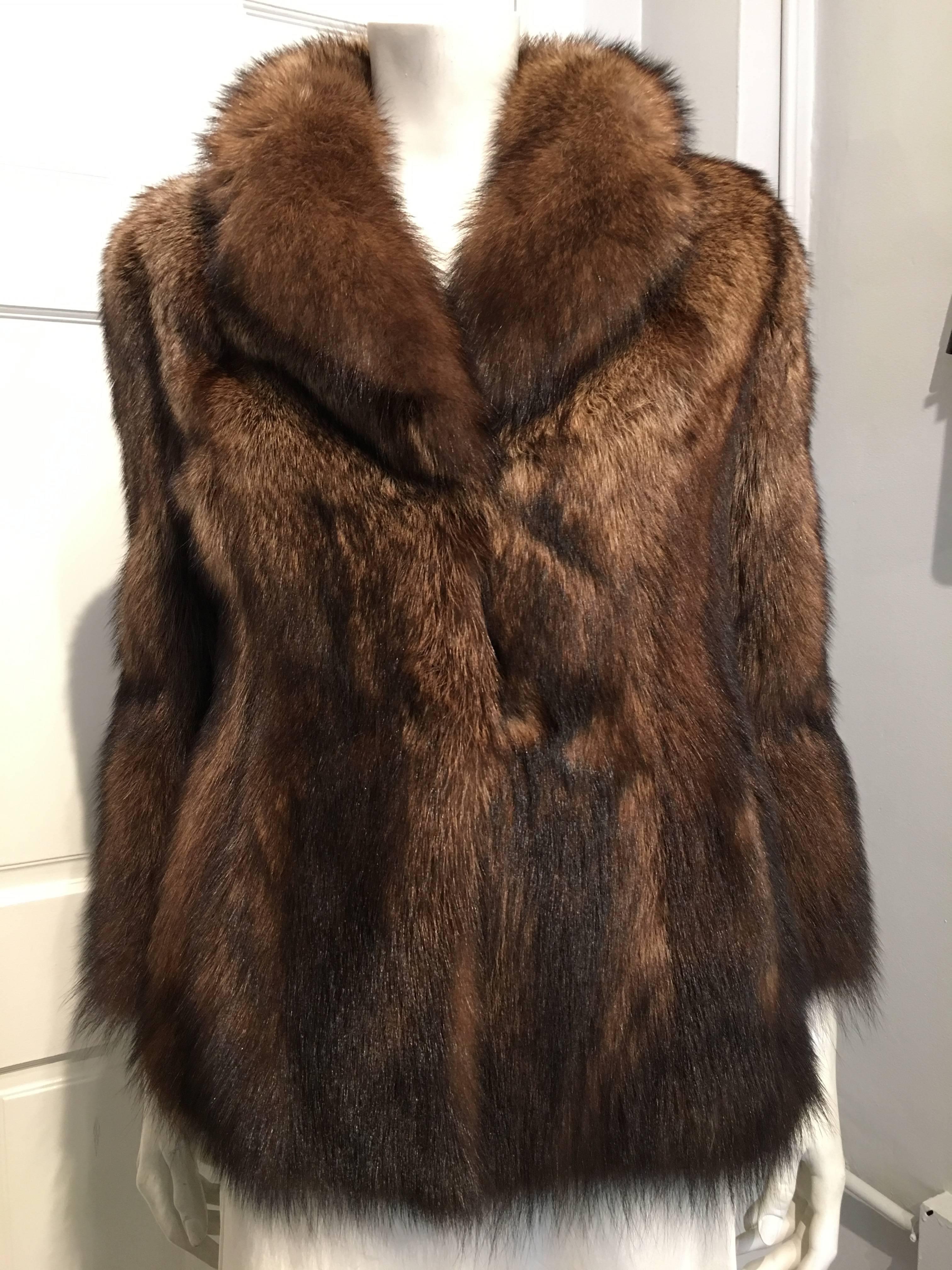 Prada brown racoon jacket with pelts getting darker at the bottom of the body and full length sleeves. The jacket closes with three concealed hooks.
The furs used in this piece are from Saga Furs.