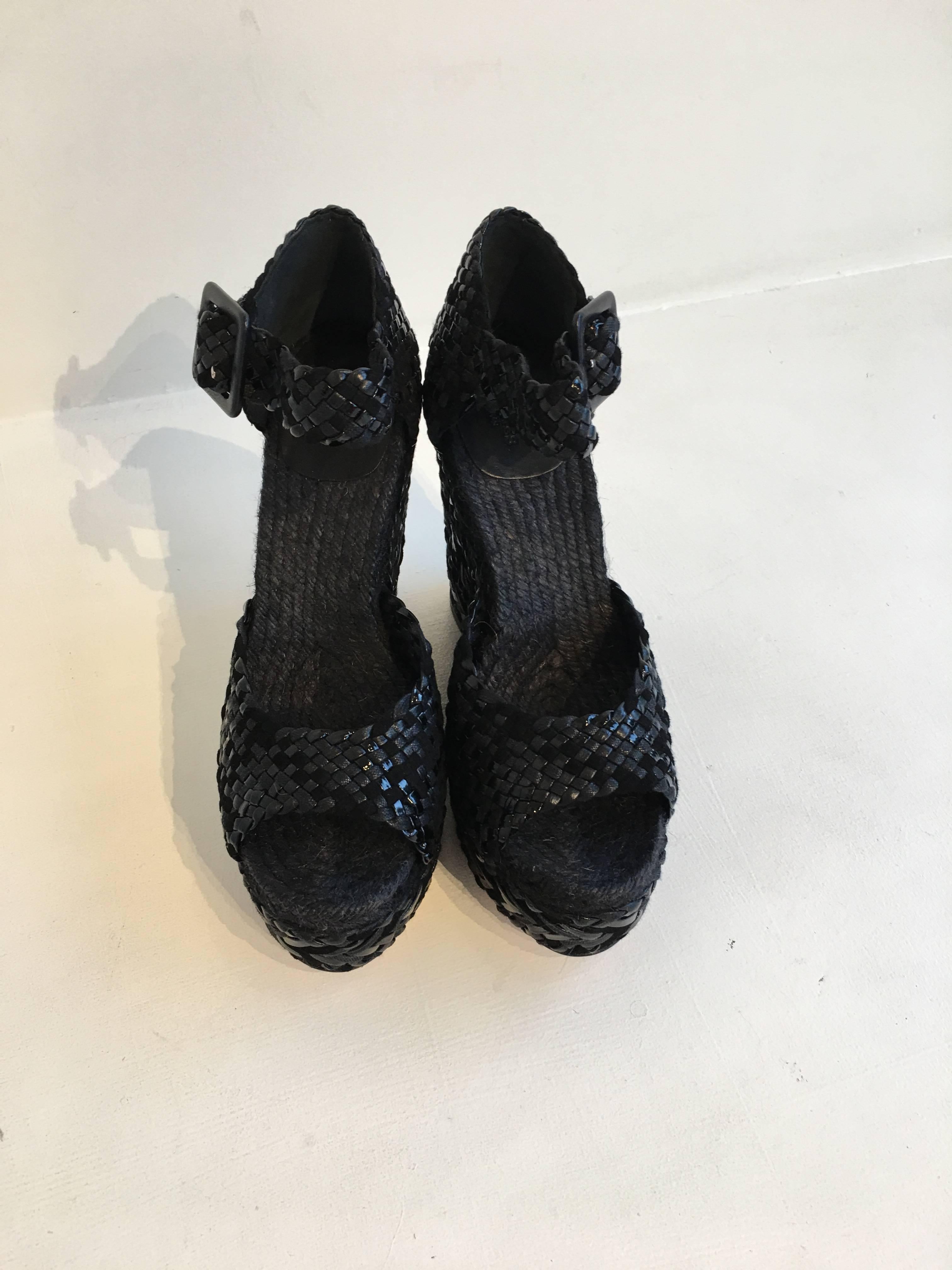 Hermes woven wedges in a mix of black suede and black patent leather, in an espadrille style.The shoes feature a 1.25 inch platform and have a 3.5 inch heel, with a total height of 4.75.