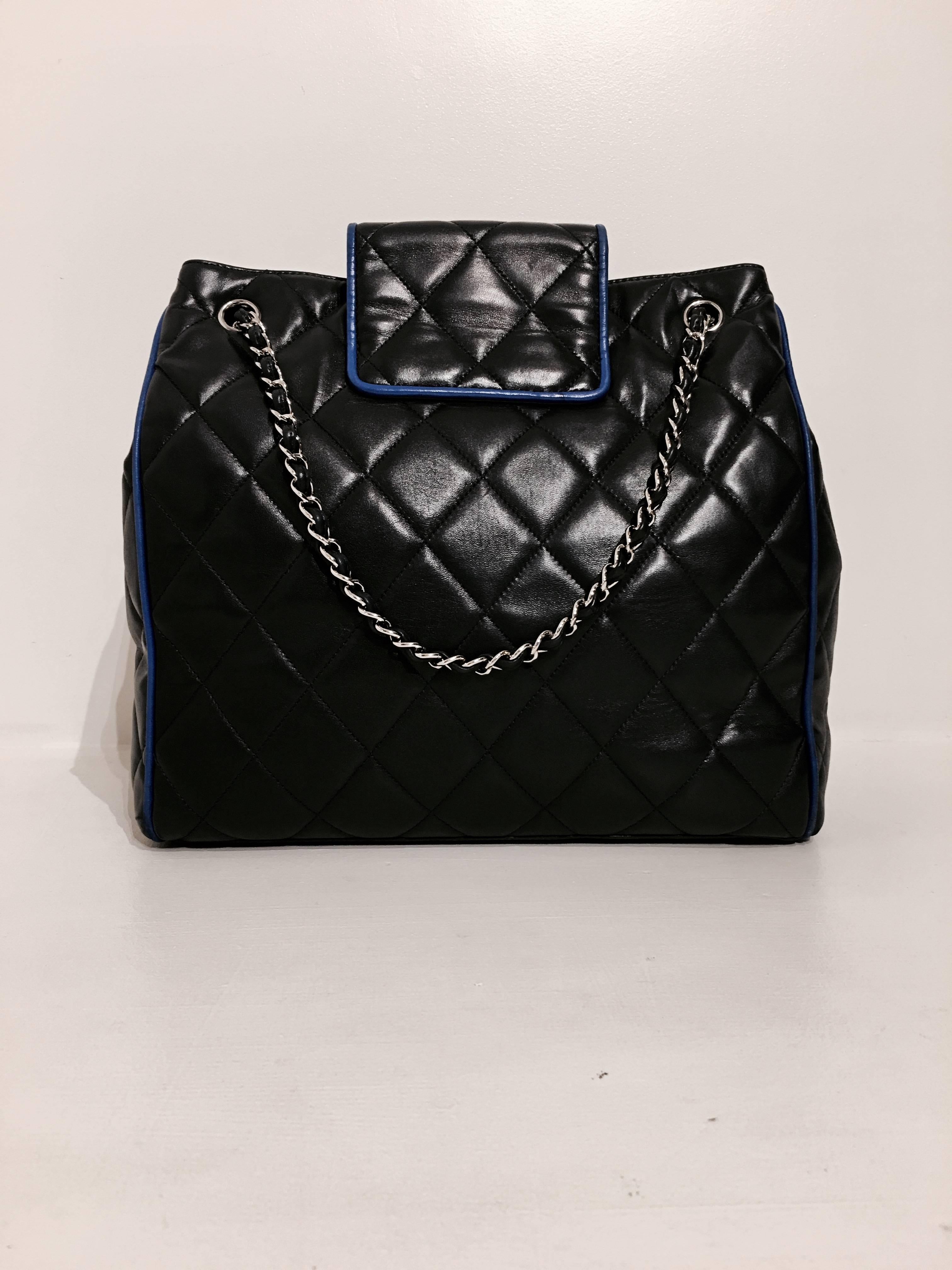 Chanel navy quilted leather bag with royal blue piping. The bag has adjustable straps in silver chain and navy leather, and the flap-closure features the double CC logo in royal blue leather